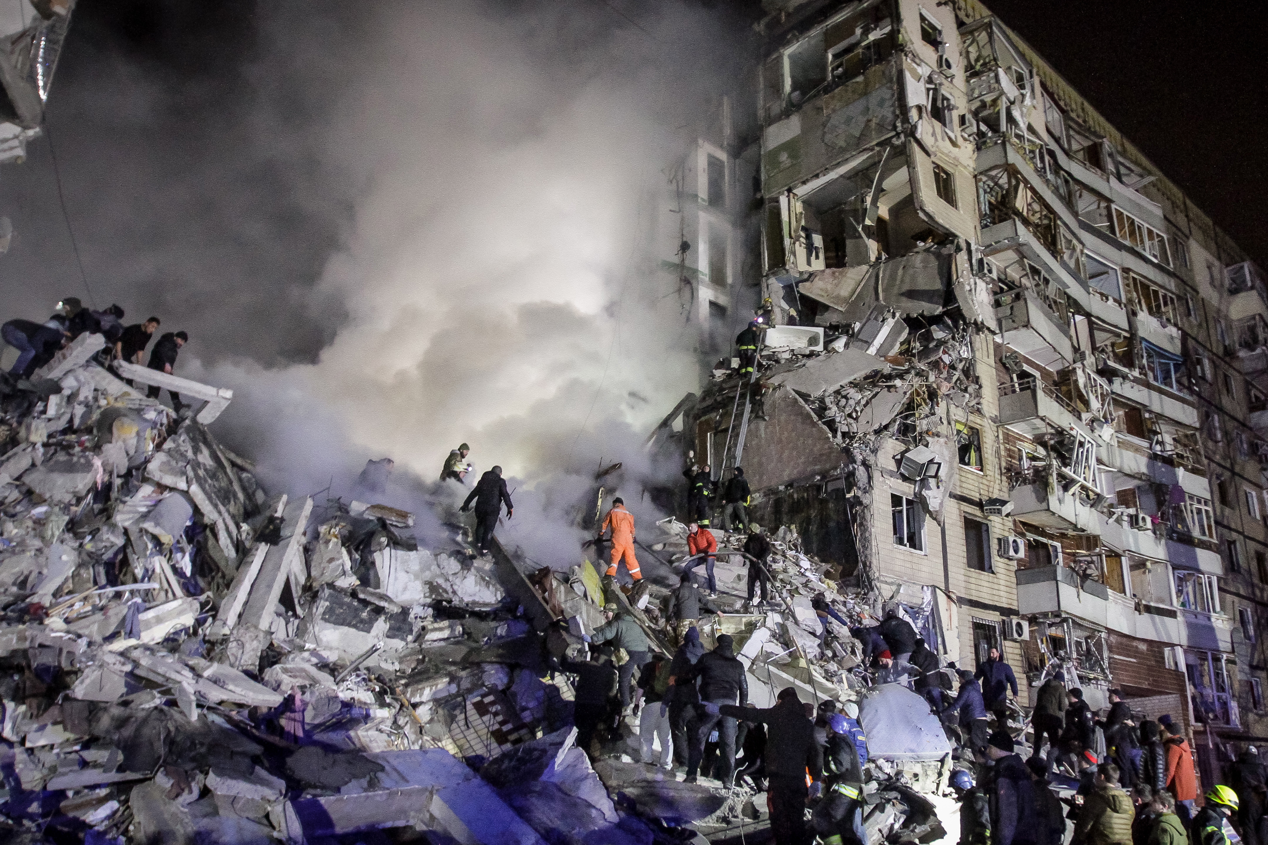 Dnipro (Ukraine), 14/01/2023.- Local residents help with rescue operations at the site of a damaged residential building hit by shelling in Dnipro, southeastern Ukraine, 14 January 2023, amid Russia's invasion. At least five people died and 64 others were injured, including 14 children, after a rocket hit the nine-story building in Dnipro, the State Emergency Service (SES) of Ukraine reported on 14 January. Russian troops entered Ukraine on 24 February 2022 starting a conflict that has provoked destruction and a humanitarian crisis. (Rusia, Ucrania) EFE/EPA/STR