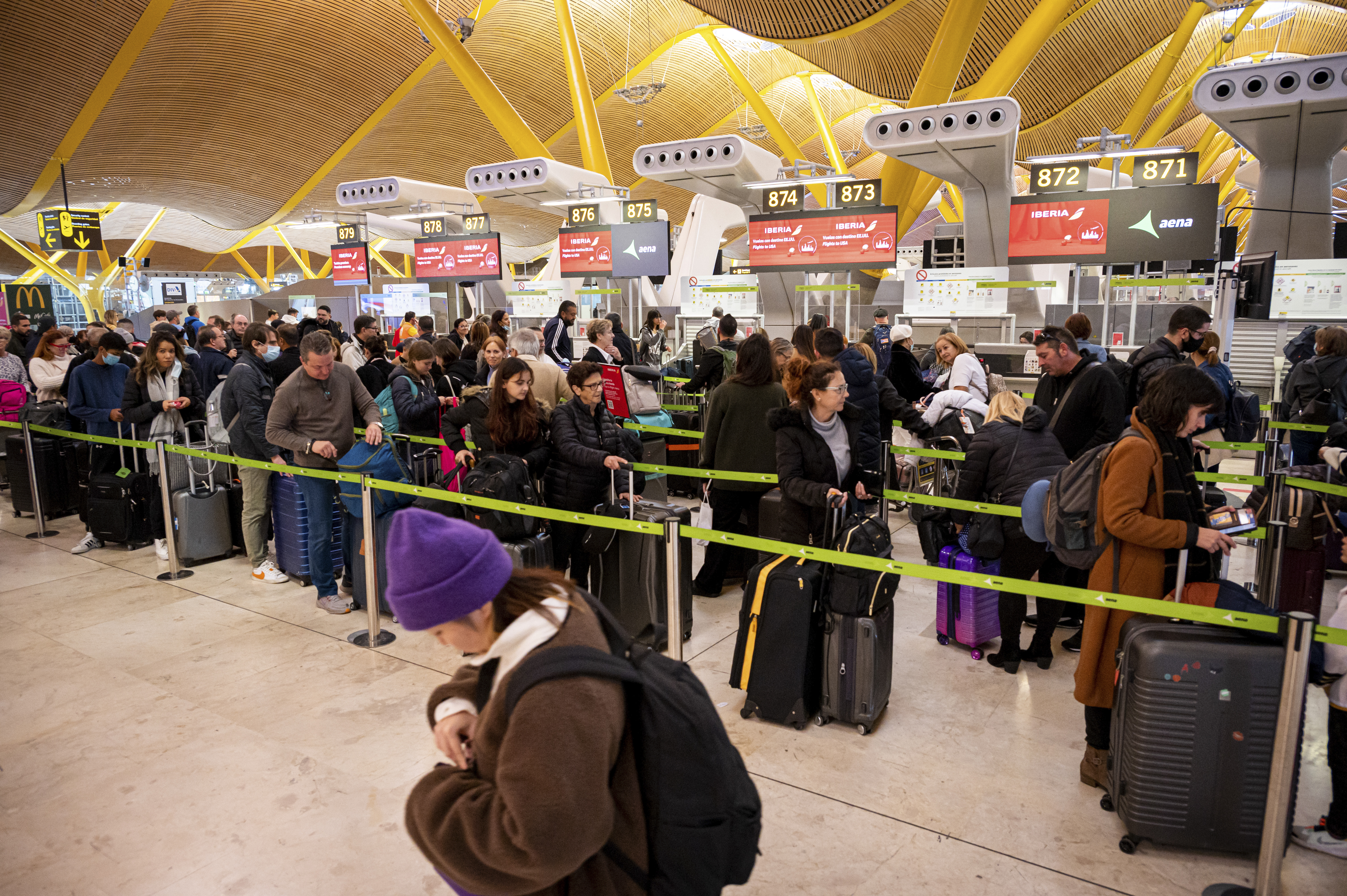 MADRID, 30/12/2022.- Numerosos viajeros hacen cola ante los mostradores de check-in de las compañías aéreas este viernes en el aeropuerto de Madrid Barajas, Muchas son las personas que se desplazan para pasar el fin de año y celebrar la entrada de 2023 en otro lugar o regresan a sus hogares. EFE/ Fernando Villar
