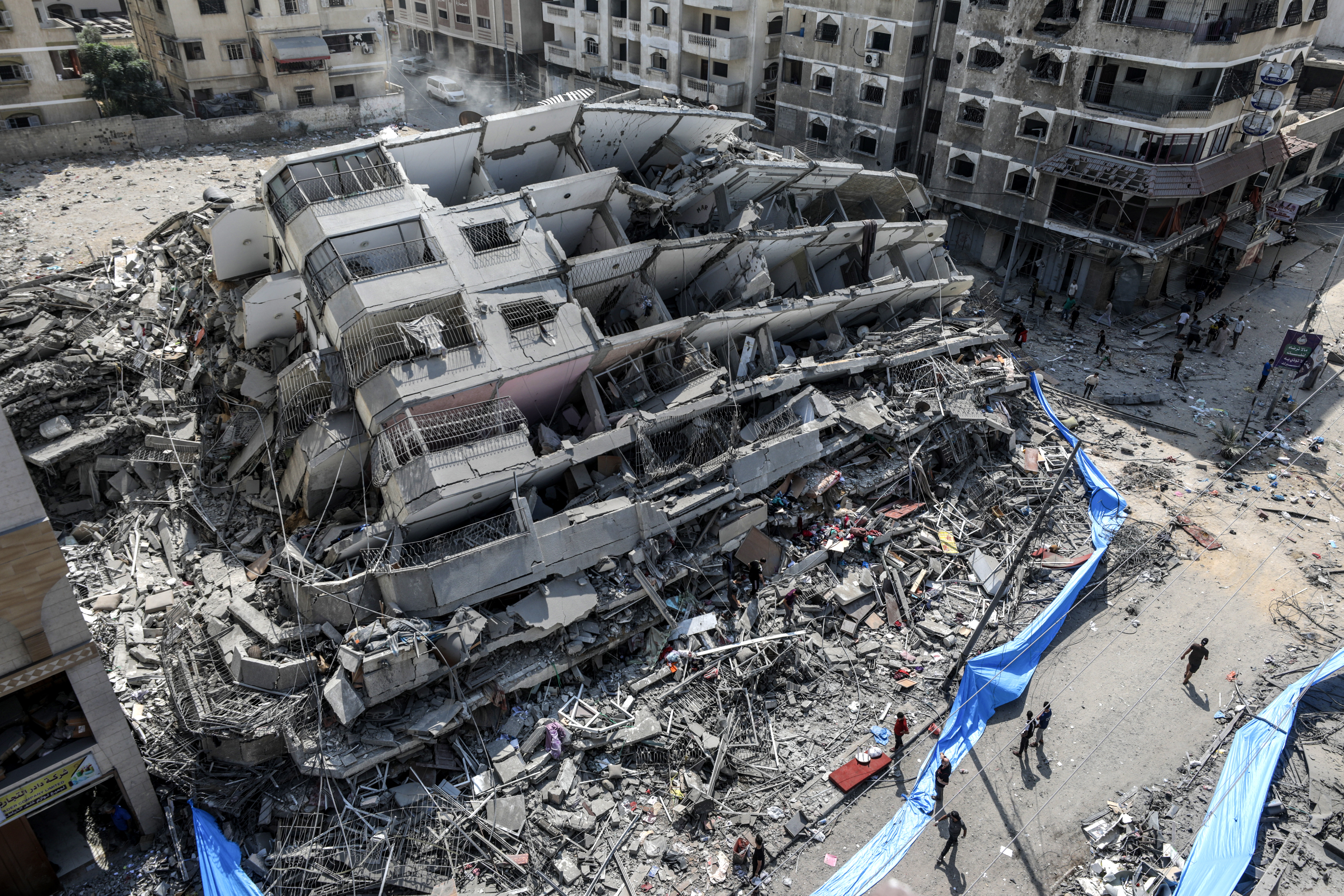 Gaza (---), 08/10/2023.- An aerial view shows people inspecting the destroyed Al-Aklouk Tower following Israeli air strikes, in Gaza City, 08 October 2023. The air strikes, in retaliation for the 07 October Hamas rocket attacks on Israel, have killed over 300 people in the Gaza Strip, with almost 2,000 wounded, according to Palestinian official sources. EFE/EPA/MOHAMMED SABER