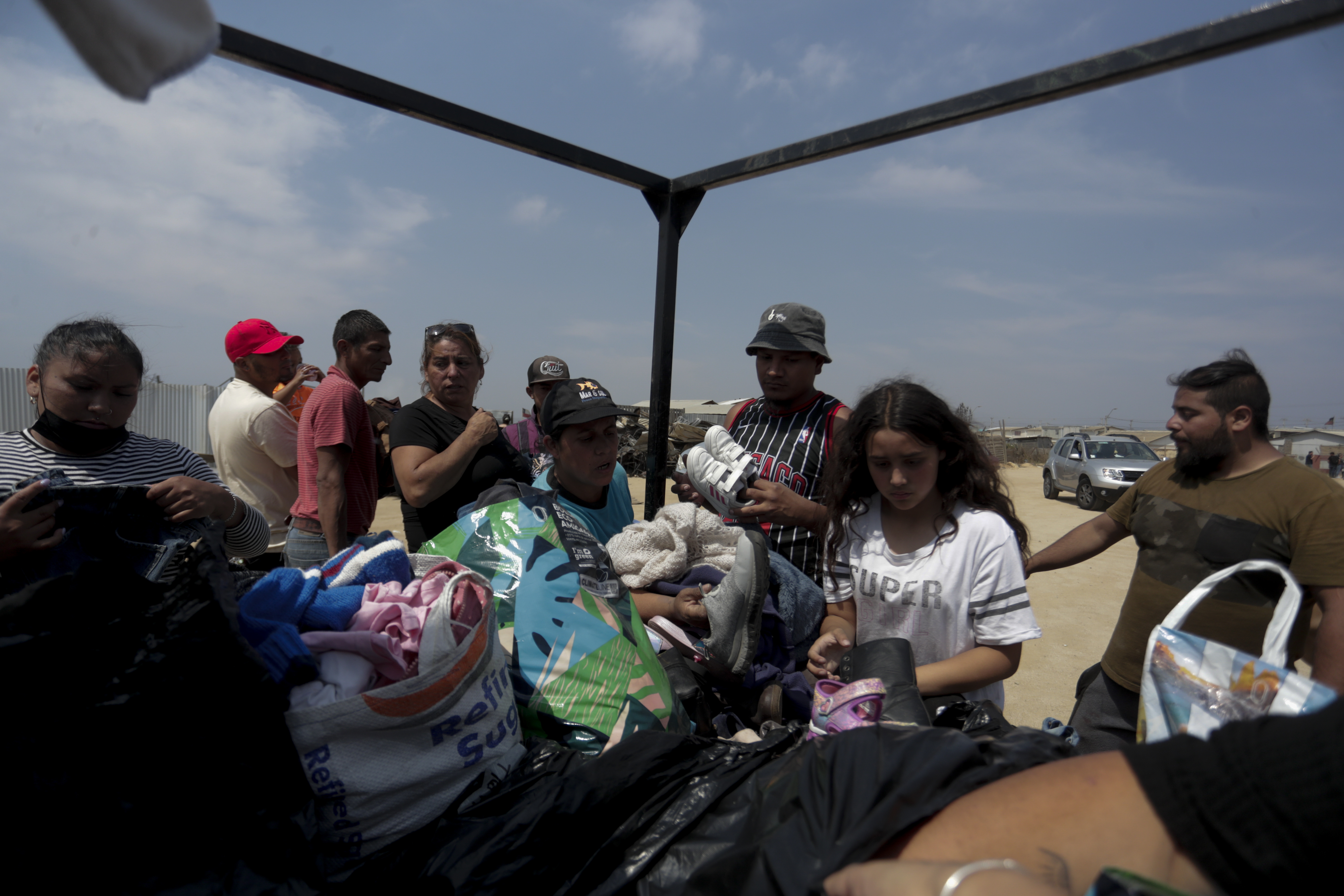 AME5705. VIÑA DEL MAR (CHILE), 04/02/2024.- Personas llegan hoy en camión a repartir ropa para las personas damnificadas en el campamento irregular “Pompeya” , tras los incendios del día viernes 2 de febrero, en la zona de Viña del Mar, Región de Valparaiso (Chile). En el campamento irregular “Pompeya”, uno de las “zona cero” de los mortíferos que han arrasado miles de casas y segado la vida de más de medio centenar de personas en la región costera de Valparaiso, apenas se escuchan ya lamentos. EFE/ Ailen Díaz