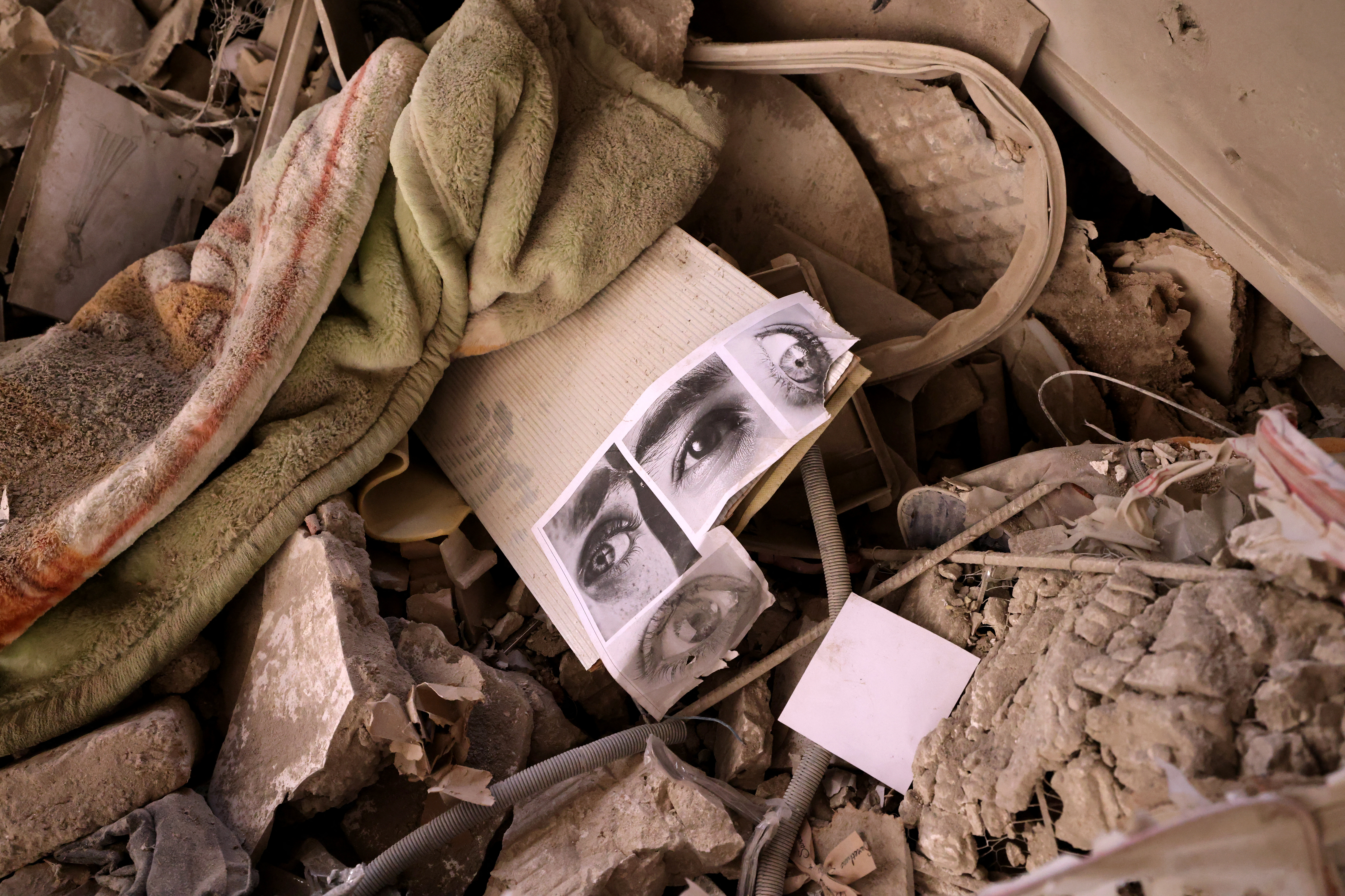 Pictures of people's eyes lie amid the rubble of a residential building that was hit in an Israeli strike, in Tehran, on June 25, 2025.