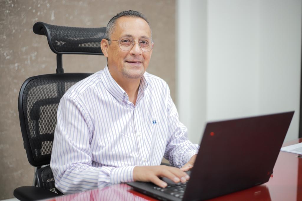 Joaquín Cortés, director de salud de Cajacopi EPS, sentado en su escritorio frente a su portátil