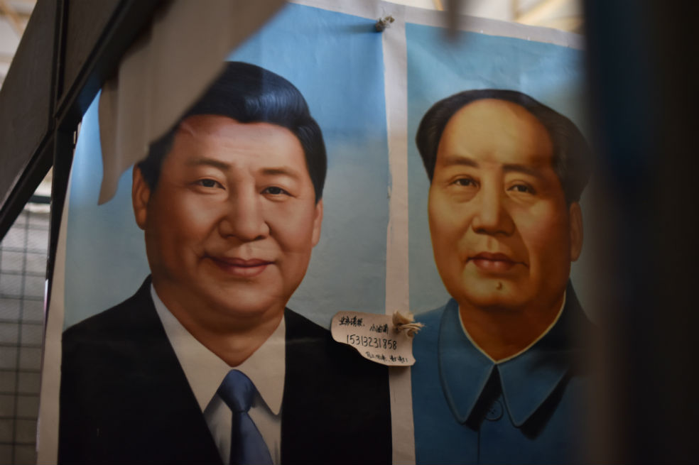 Retratos pintados del presidente chino Xi Jinping (izquierda) y del fallecido líder comunista Mao Zedong en un mercado en Beijing./AFP