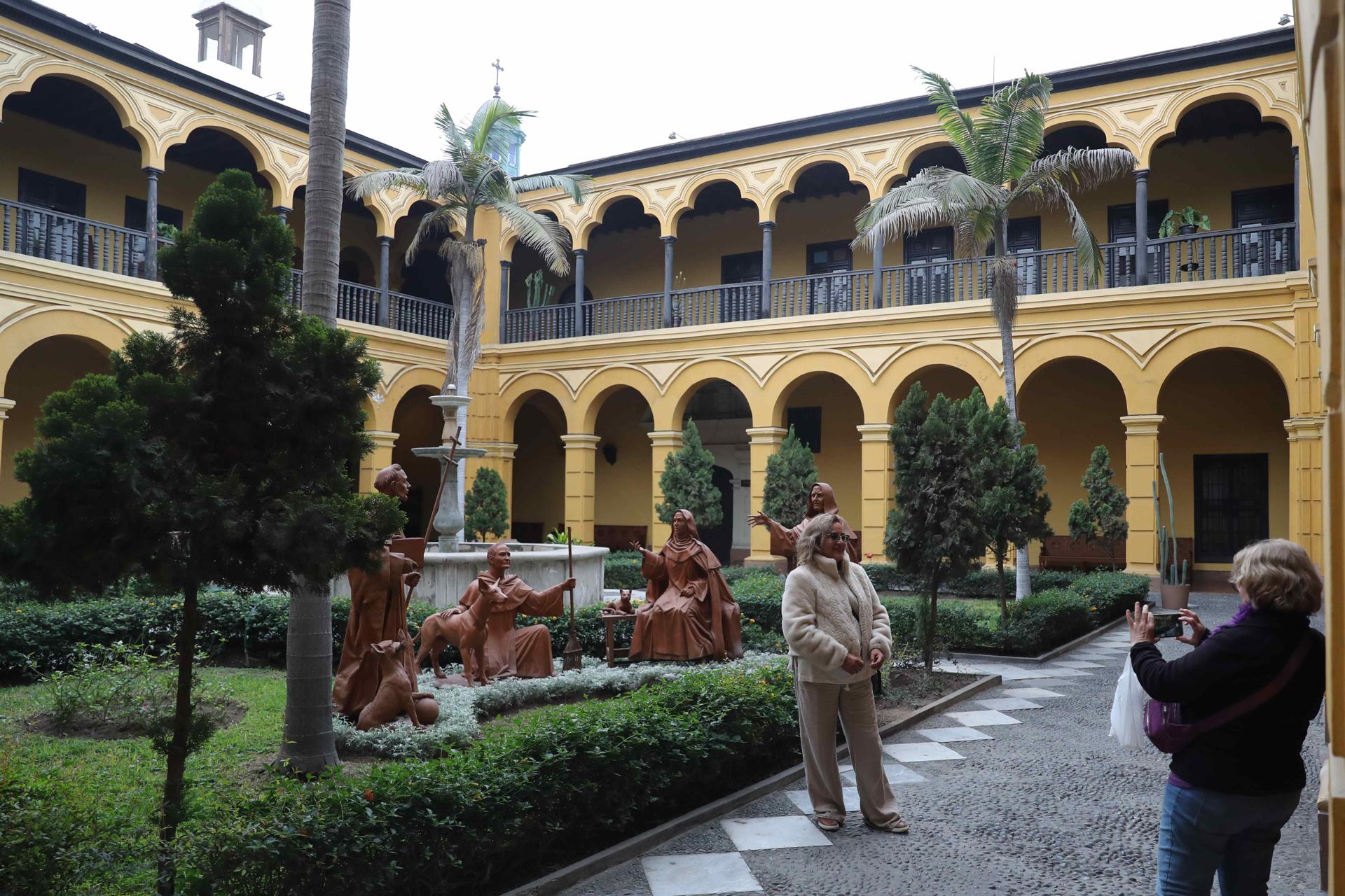 ACOMPAÑA CRÓNICA: PERÚ TURISMO AME8992. LIMA (PERÚ), 12/09/2025.- Personas se toman fotografías en un jardín del convento de Santo Domingo este lunes, en Lima (Perú). El museo del convento de Santo Domingo, la primera orden religiosa que llegó al Perú en 1535 con la expedición del fundador Francisco Pizarro, se ha convertido en un nuevo atractivo turístico del centro histórico de Lima, después de la restauración de su fachada, torre y campanario, y que aún continúa con los azulejos sevillanos que adornan sus interiores. EFE/ Paolo Aguilar
