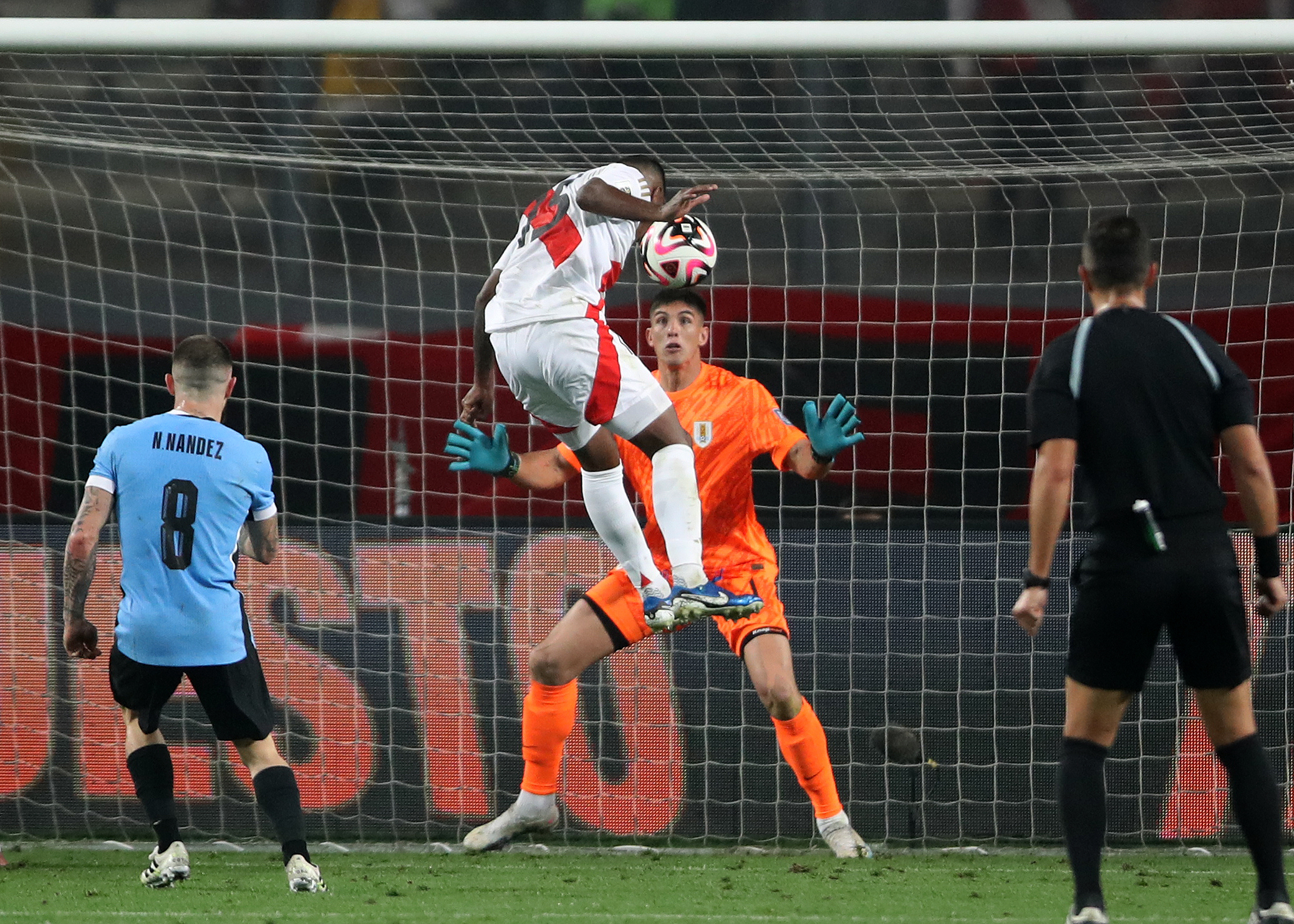 . LIMA (PERÚ), 11/10/2024.- Miguel Araujo (i) de Perú cabecea un balón ante Sergio Rochet de Uruguay este viernes, en un partido de las eliminatorias sudamericanas para el Mundial de 2026 entre Perú y Uruguay en el estadio Nacional de Perú en Lima (Perú). EFE/ Paolo Aguilar