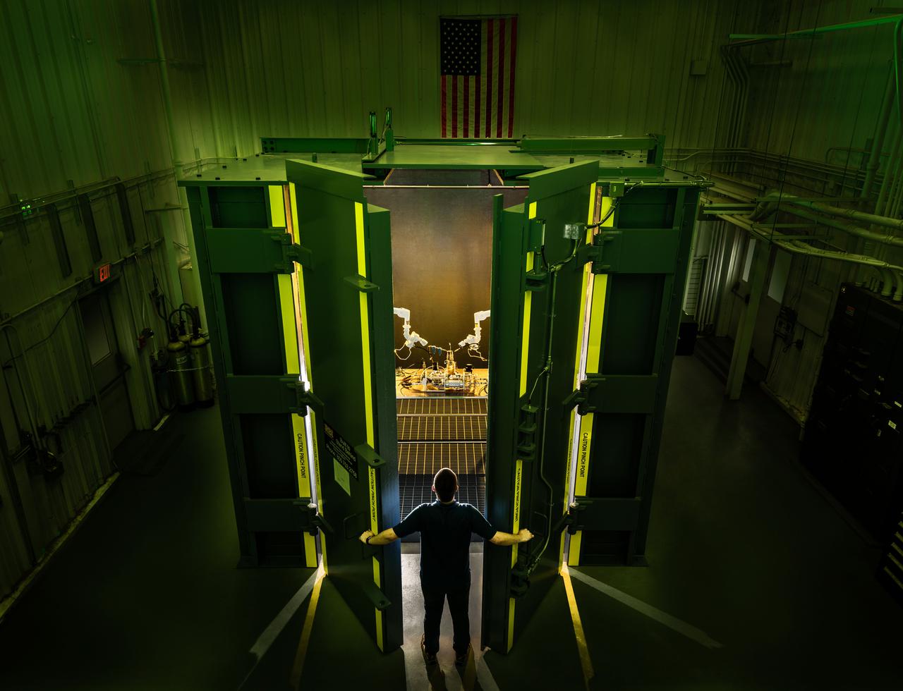 El ingeniero de pruebas Chris McWilliams observa el equipo de prueba en el gabinete de prueba de alta presión de la caja de auge en el edificio 353H en el área de prueba de sistemas de energía del Johnson Space Center