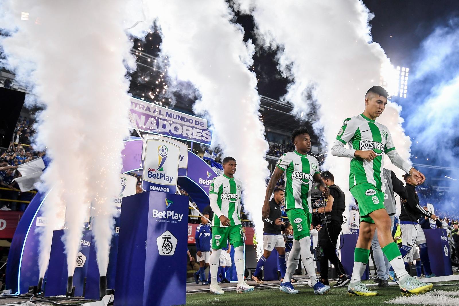 Los jugadores de Millonarios y Nacional saltaron al terreno de juego rodeados de una nube de humo azul y blanco.