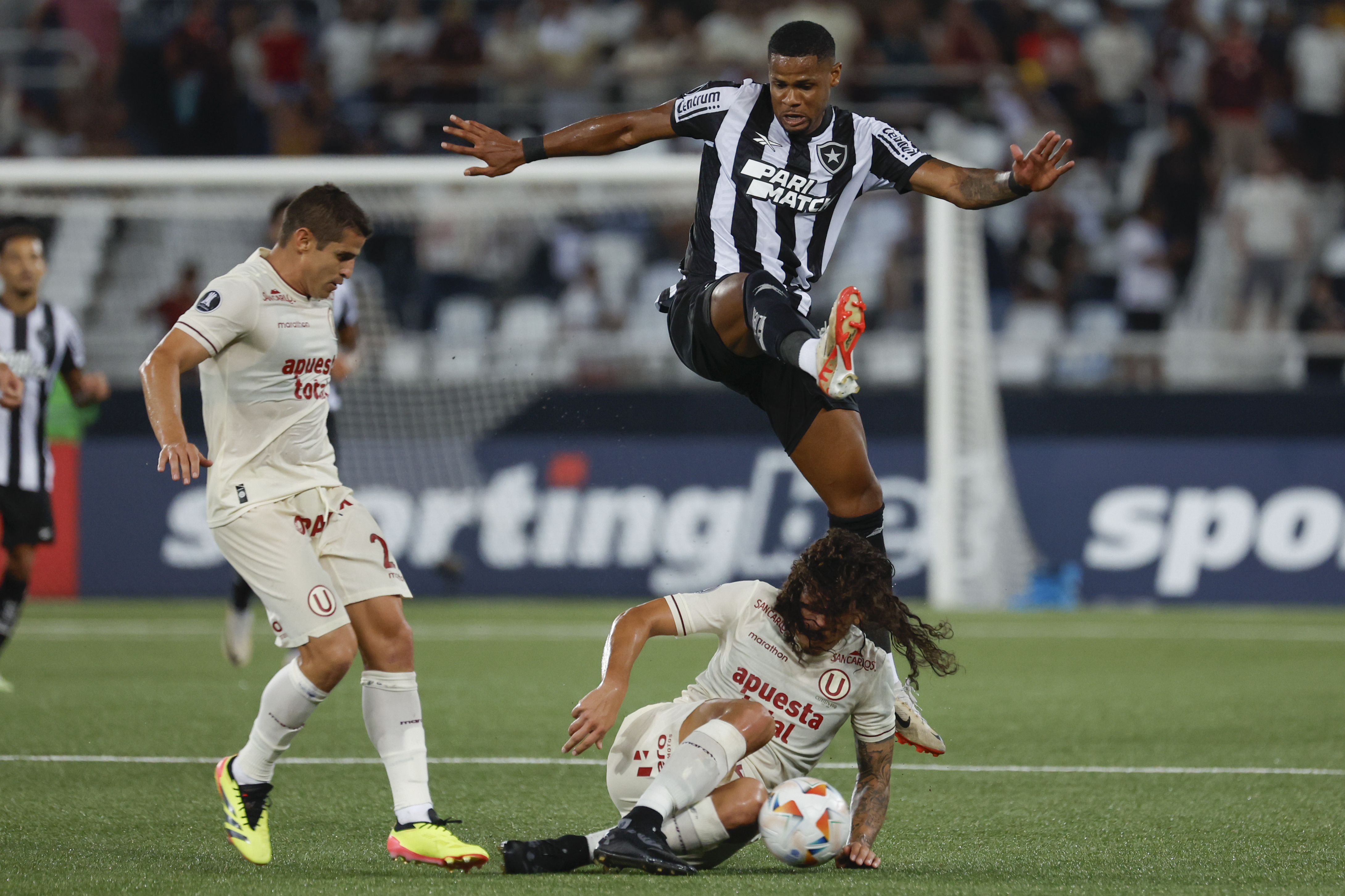 AMDEP546. RÍO DE JANEIRO (BRASIL), 24/04/2024.- Júnior Santos (arriba) de Botafogo disputa el balón con William Riveros de Universitario este miércoles, en un partido de la fase de grupos de la Copa Libertadores entre Botafogo y Universitario en el estadio Nilton Santos en Río de Janeiro (Brasil). EFE/ Antonio Lacerda