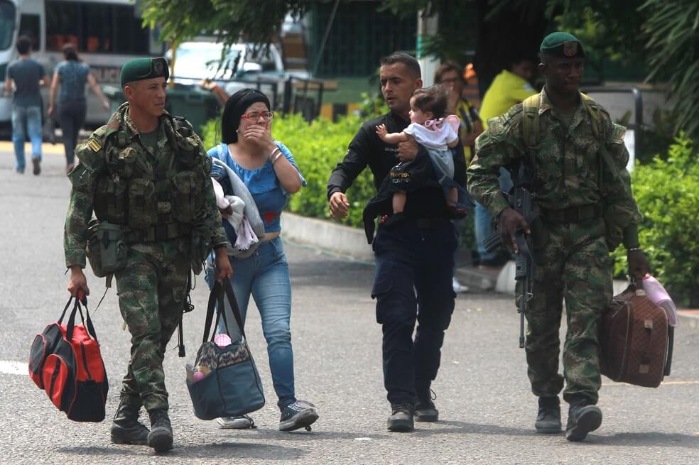 Soldados colombianos acompañan a un policía venezolano, acompañado de su hija y su esposa , luego de desertar este miércoles en el puente Simón Bolívar, en Cúcuta. / EFE