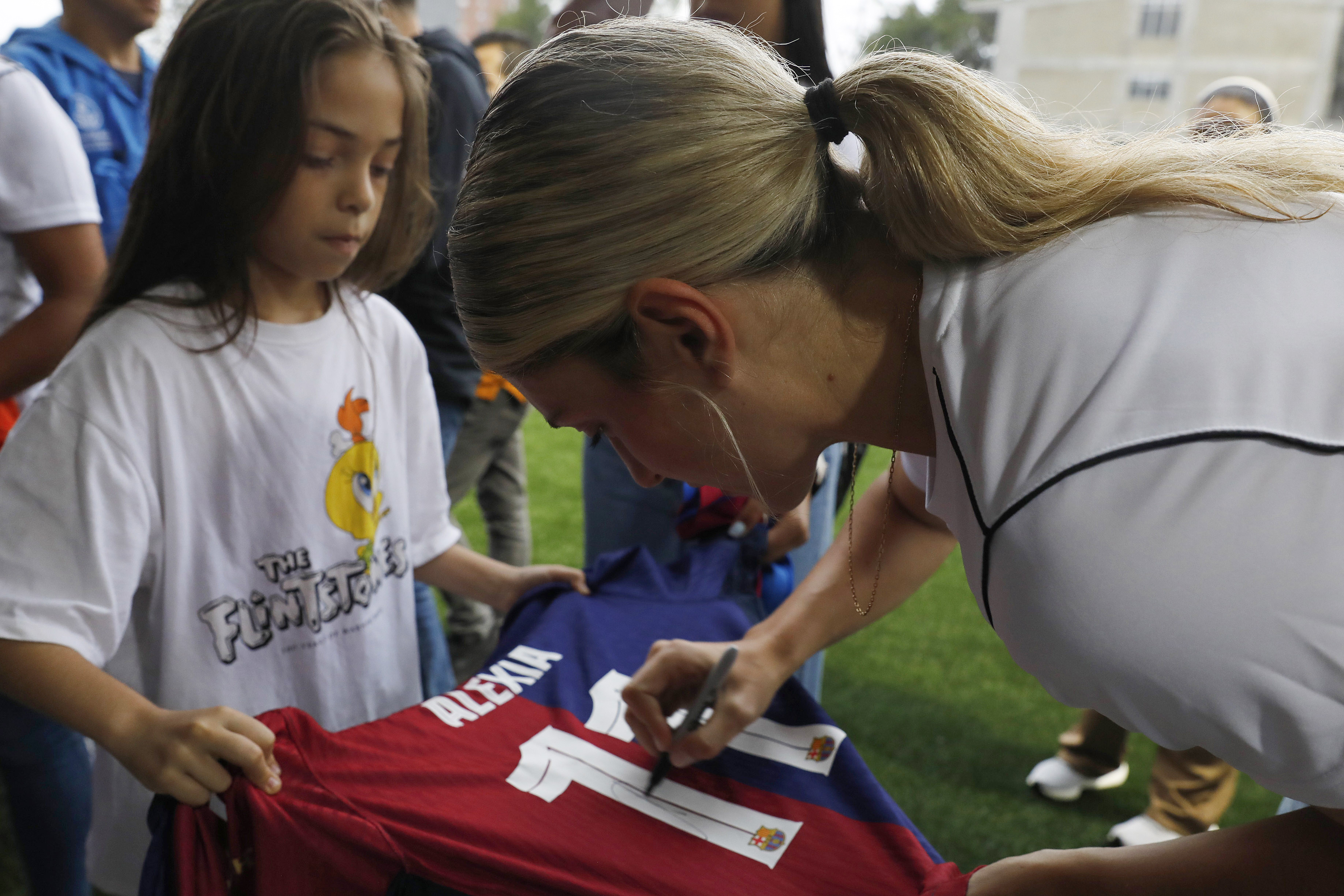 AME5278. ITAGÜÍ (COLOMBIA), 19/06/2024.- La futbolista del Barcelona Alexia Putellas firma una camiseta a una seguidora en un acto este miércoles, en Itagüí (Colombia). Putellas a través de su fundación 'Eleven' y la alcaldía de Itagüí abrirán la primera academia de fútbol de su fundación. La futbolista Alexia Putellas, campeona del mundo con el seleccionado español y doble ganadora del Balón de Oro, inauguró hoy en el municipio colombiano de Itagüí la primera sede de su academia en Latinoamérica. EFE/ Luis Eduardo Noriega Arboleda