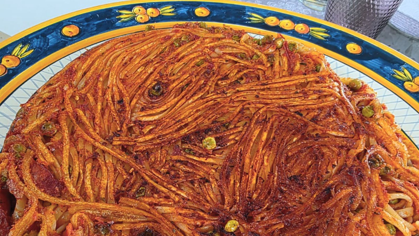 La pasta asesina (assassina) se cocina directamente en la sartén con salsa y caldo de tomate, logrando una irresistible costra dorada y crujiente.