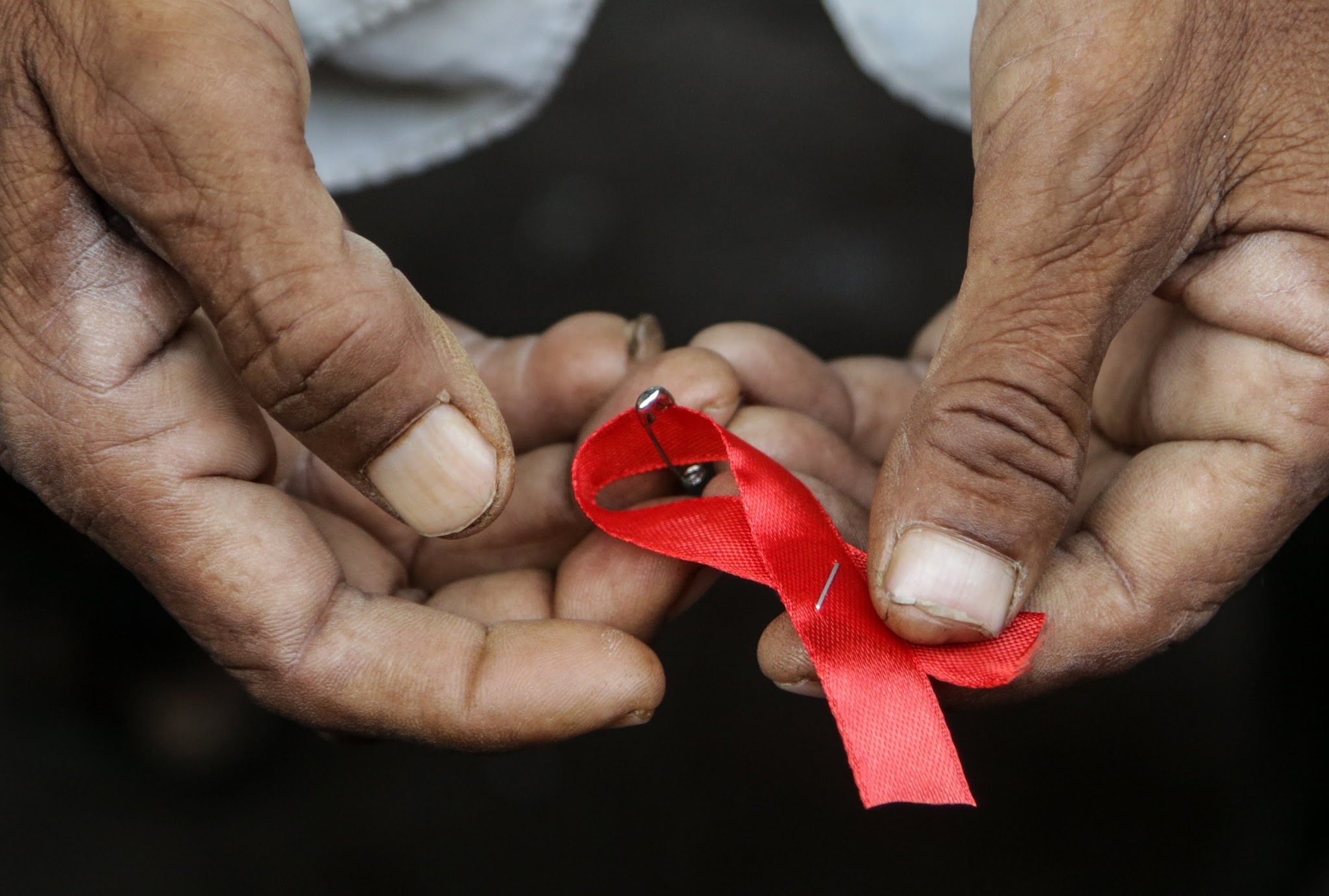 SOL01. MUMBAI (INDIA), 30/11/2017.- Un hombre sostiene el lazo rojo que conmemora el Día Mundial de la Lucha contra el Sida, durante un evento para la concienciación del Sida, organizado por la Integración de las actividades sociales de las ONG (SAI), en las calles de Kamathipura, en Mumbai (India) hoy, 30 de noviembre de 2017. Según la ONU, cerda de un millón de personas fallecieron a causa de enfermedades relacionadas con el sida en 2016. EFE/ Divyakant Solanki