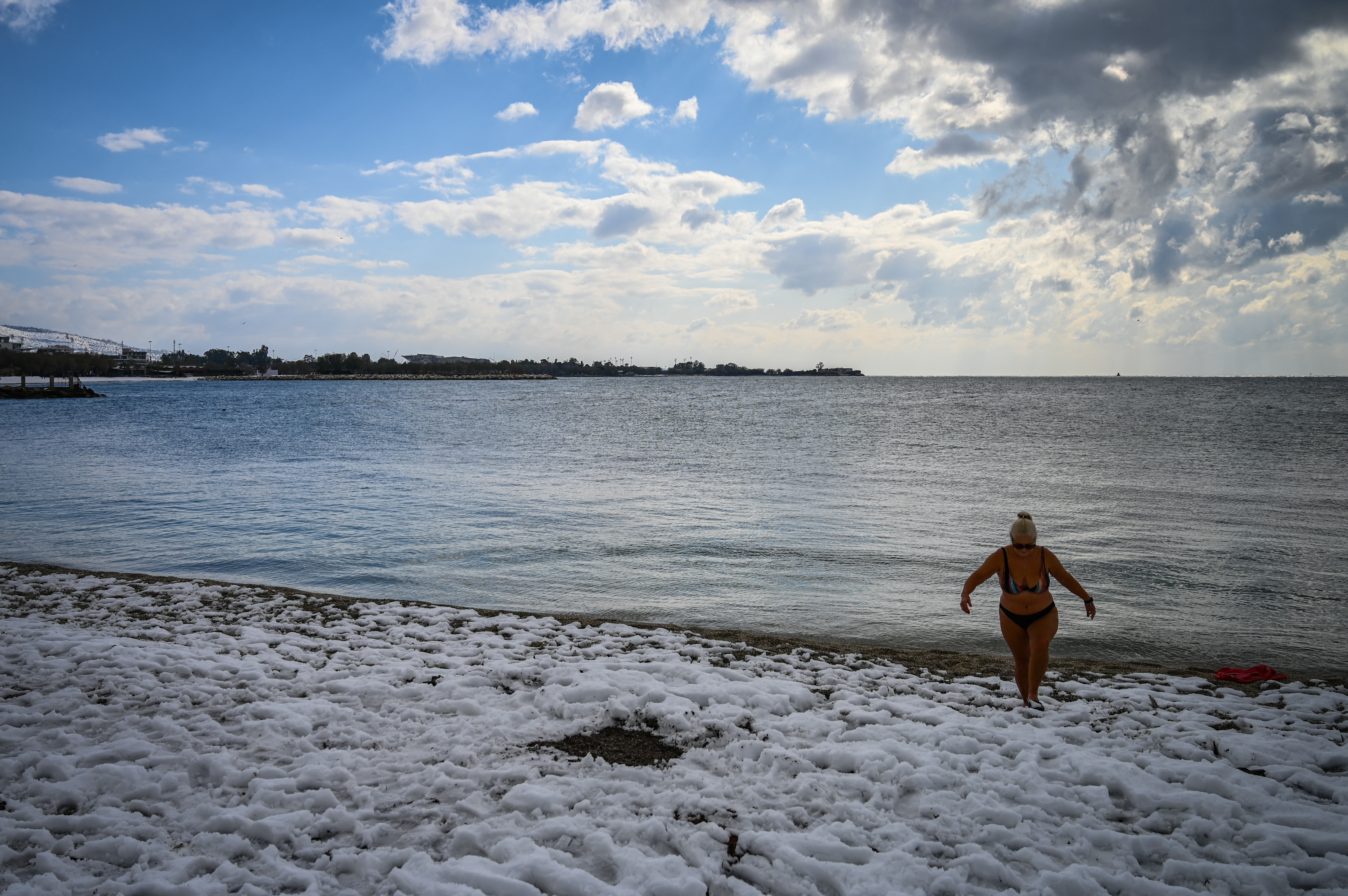 Una mujer pasea en traje de baño en medio de la nieve que dejó la tormenta.