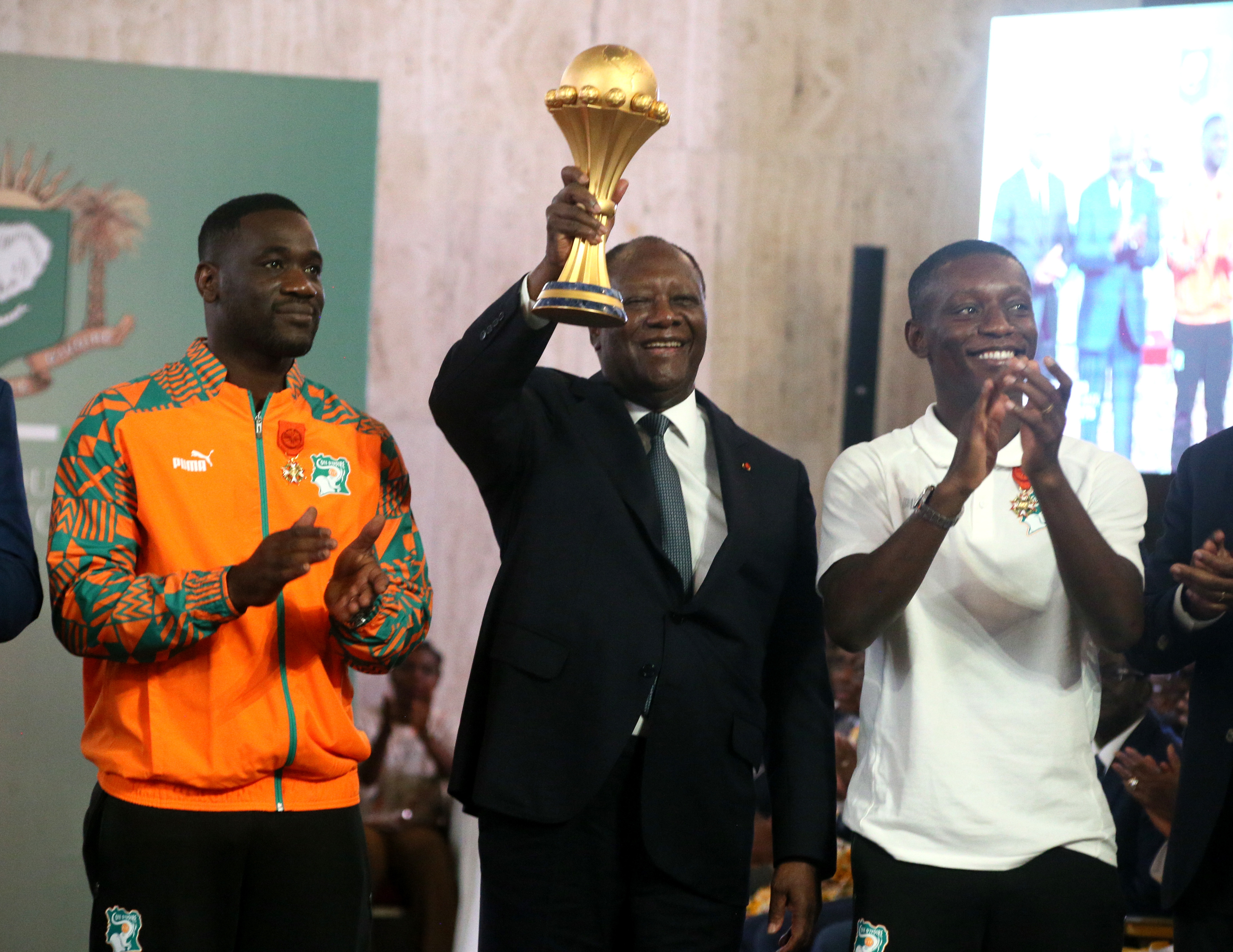 Abidjan (Cote D''ivoire), 13/02/2024.- President of Ivory Coast Alassane Ouattara (C) holds the trophy while standing next to Ivory Coast's coach Emerse Fae (L) and Ivory Coast's captain Max-Alain Gradel during a reception at the Presidential Palace in Abidjan, Ivory Coast, 13 February 2024. Ivory Coast on 11 February won the CAF 2023 Africa Cup of Nations final against Nigeria. (Costa de Marfil) EFE/EPA/LEGNAN KOULA