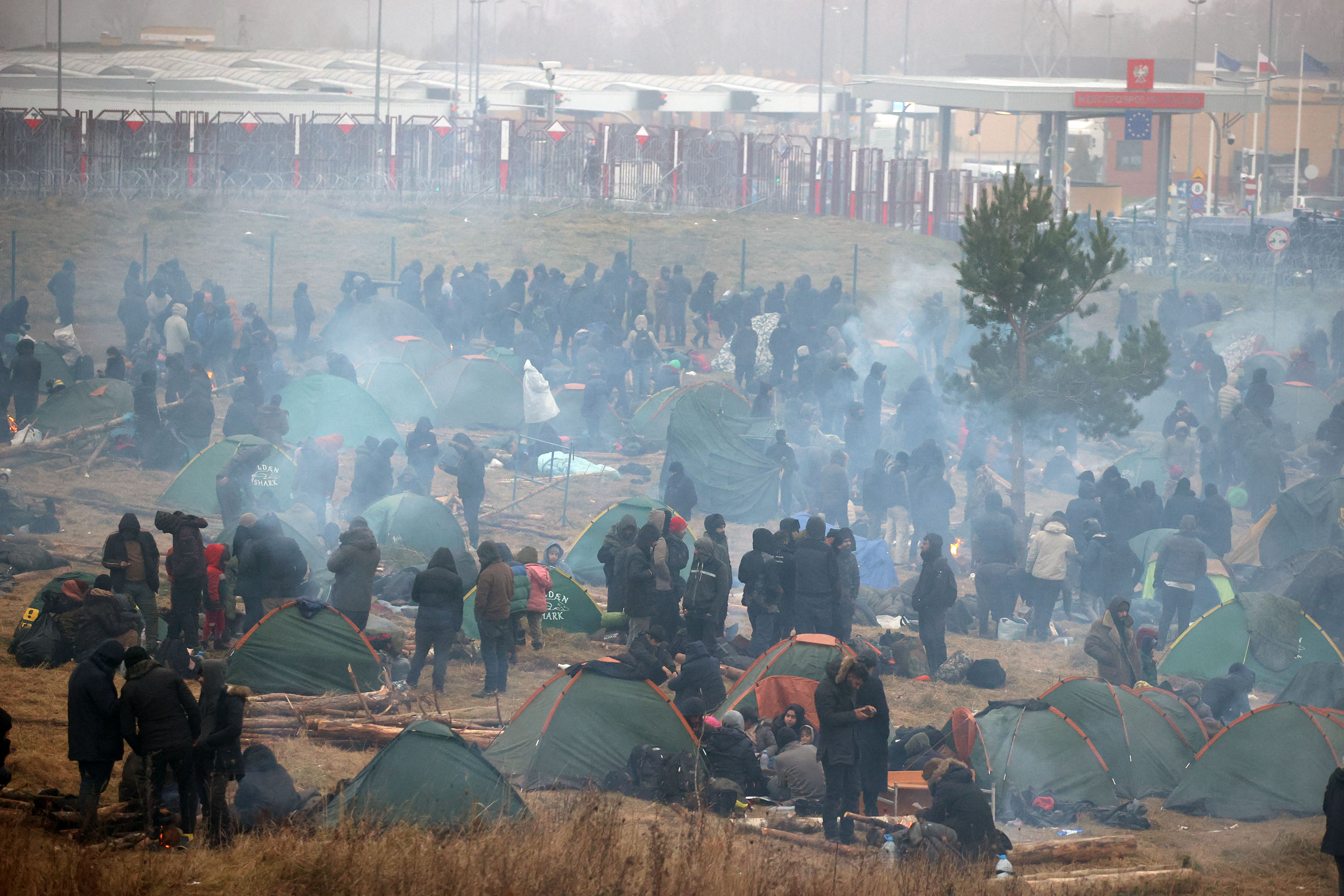 Migrants aiming to cross into Poland are seen in a camp near the Bruzgi-Kuznica border crossing on the Belarusian-Polish border on November 17, 2021. (Photo by Leonid SHCHEGLOV / BELTA / AFP) / Belarus OUT