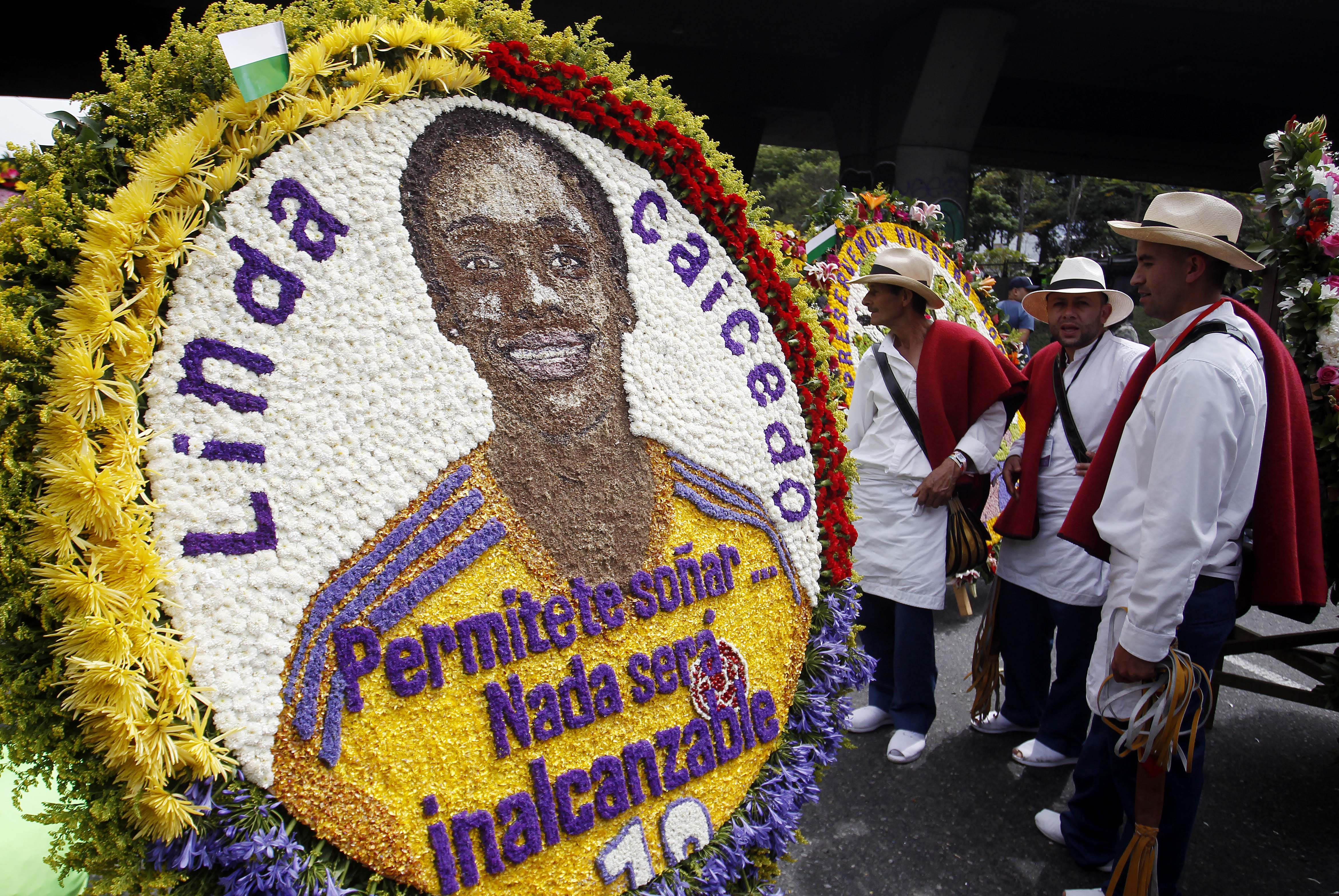 AME8869. MEDELLÍN (COLOMBIA), 07/08/2023.- Un grupo de silleteros observa una silleta en homenaje a la futbolista colombiana Linda Caicedo en la edición 66 del Desfile de Silleteros de la Feria de las Flores hoy, en Medellín (Colombia). Más de medio centenar de silleteros salieron este lunes de sus pintorescas fincas en el caserío de Santa Elena, donde nació hace 66 años esta tradición, para desfilar sus majestuoso arreglos florales y convertir a Medellín en un jardín como gran cierre de la Feria de las Flores. EFE/ Luis Eduardo Noriega A.