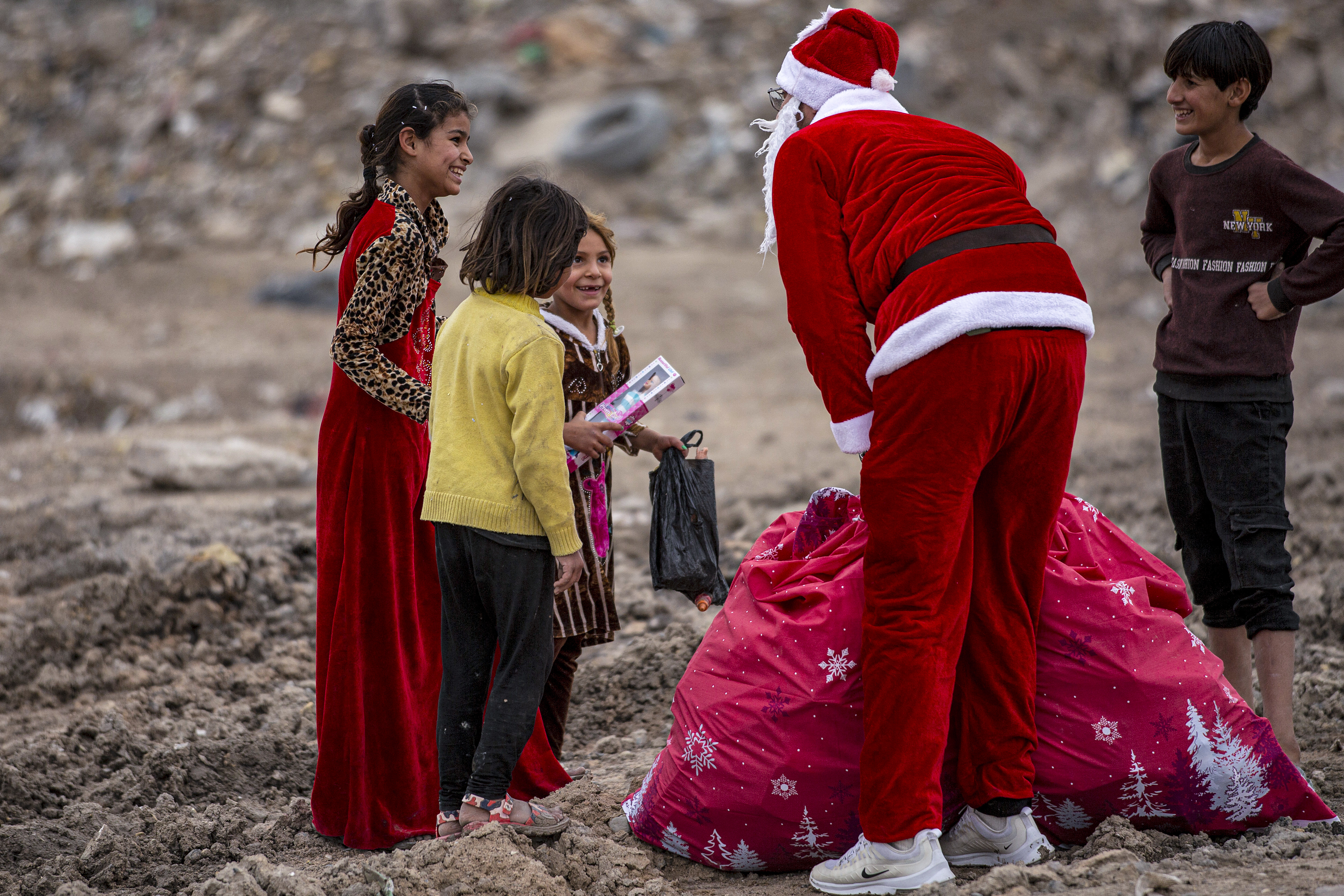 Irak: Mohamed Maarouf, de 28 años, vestido con el traje de Papá Noel, distribuye regalos de Navidad a niños pobres que viven en barrios marginales cerca del centro de la ciudad de Basora, en el sur de Irak.