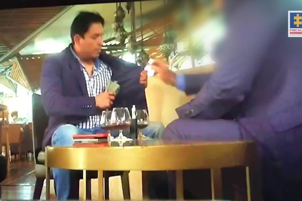 El momento en que el fiscal de la JEP capturado recibe un fajo de dinero