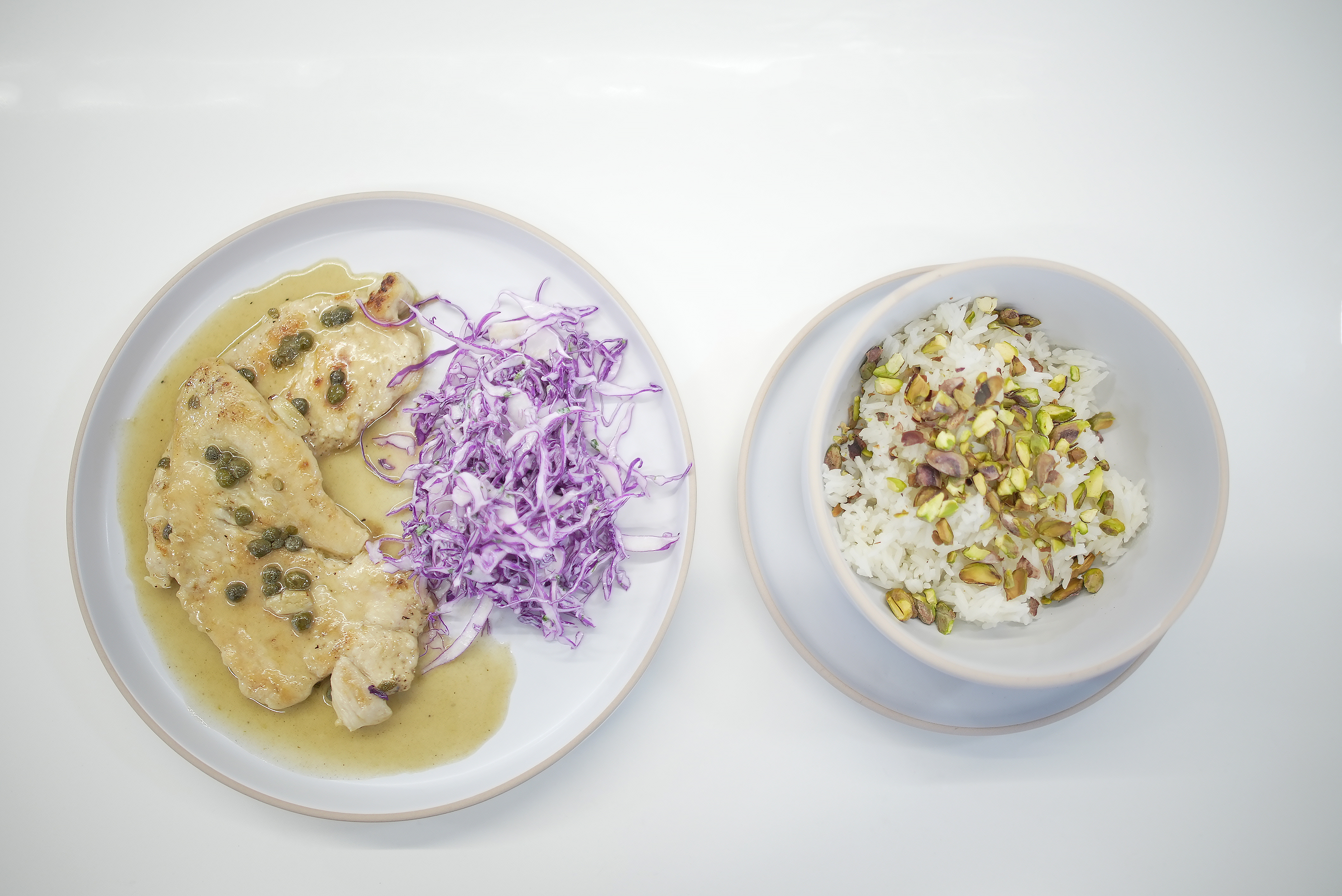 Prepara pollo piccata servido con ensalada de repollo y arroz con pistachos