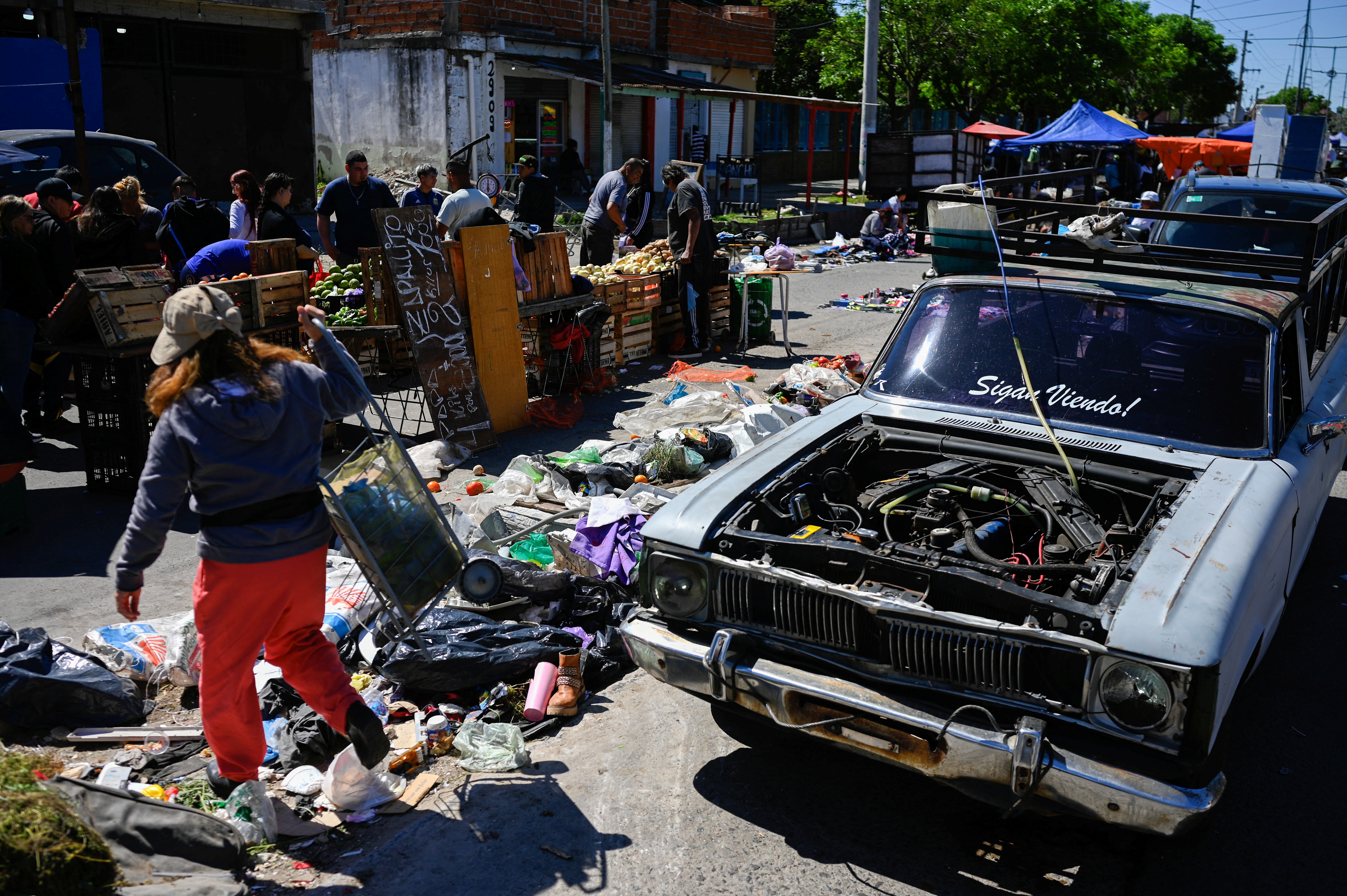 Una mujer camina con su carrito de compras por un mercado callejero en Villa Fiorito, en las afueras de Buenos Aires, el 19 de octubre de 2025.