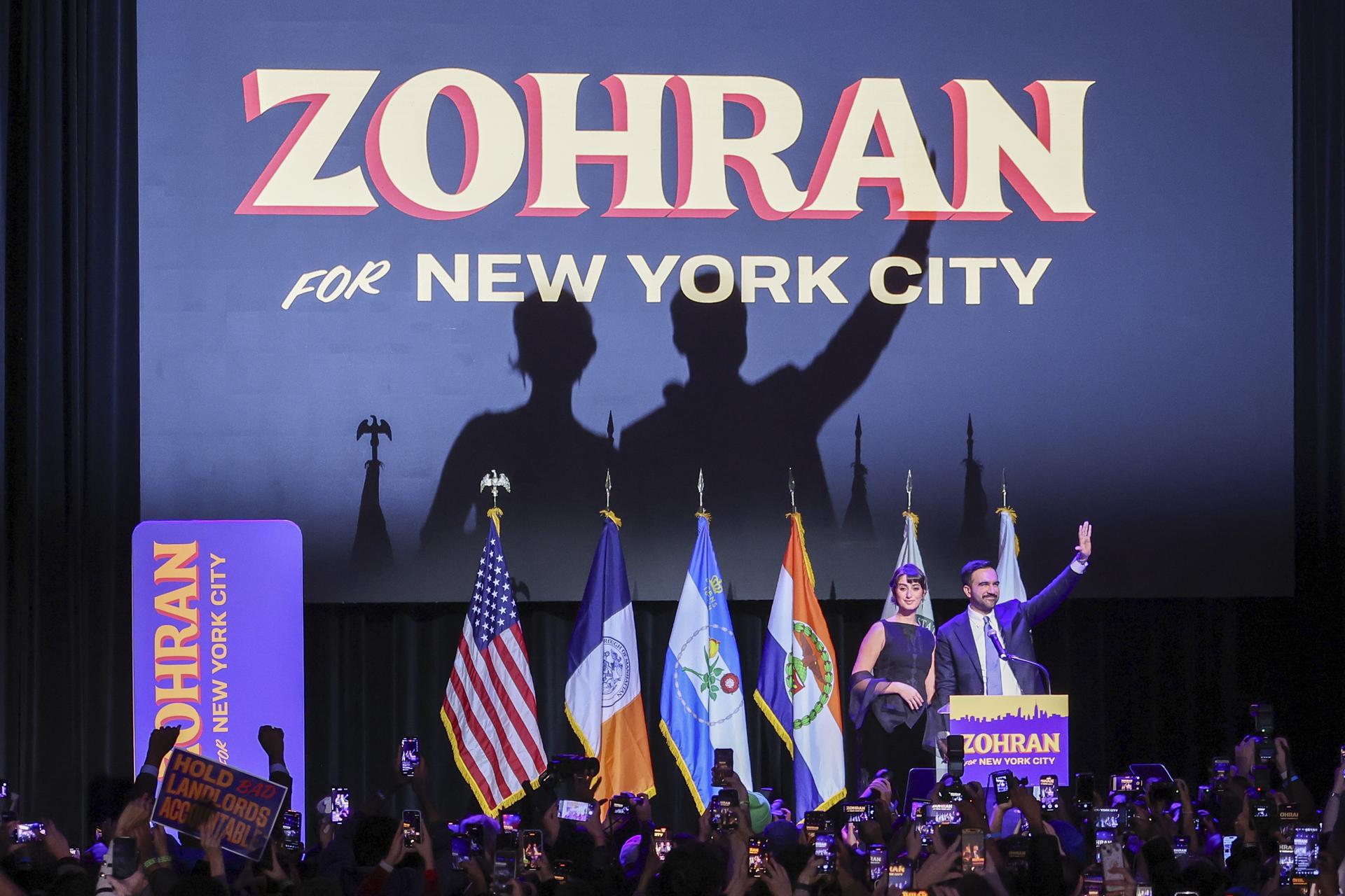 FOTODELDÍA NUEVA YORK (Estados Unidos), 05/11/2025.- El alcalde electo de la ciudad de Nueva York, Zohran Mamdani (i), y su esposa, Rama Duwaji (d), saludan a la multitud durante una fiesta celebrada por el candidato demócrata en Brooklyn, Nueva York. Mamdani derrotó a Andrew Cuomo en las elecciones a la alcaldía de Nueva York.- EFE/ Sarah Yenesel