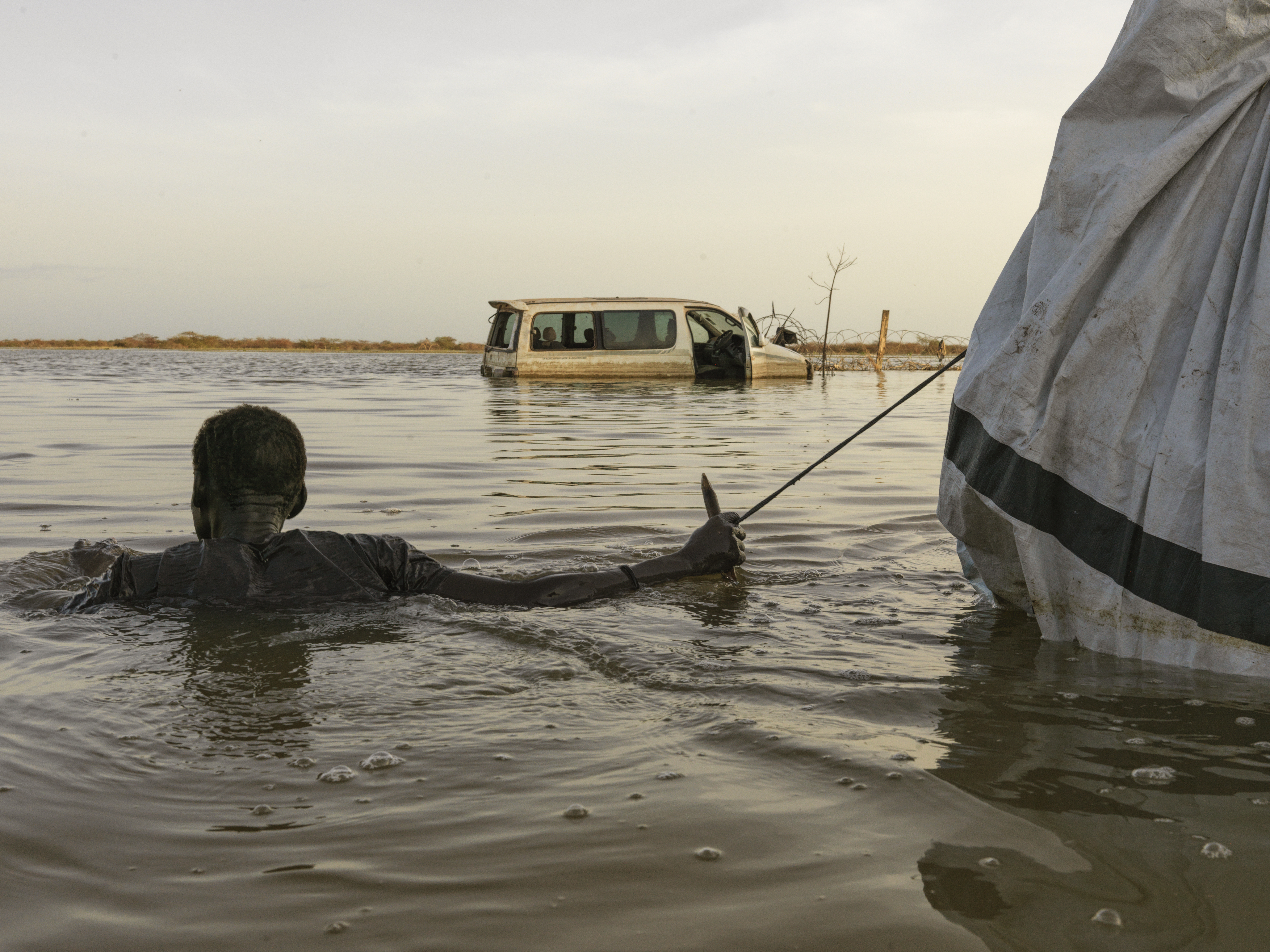 Un hombre saca sus pertenencias a través de las aguas de la inundación en Bentiu. Las inundaciones en el estado de Unity han devastado la zona, obligando a la gente a abandonar sus hogares en busca de seguridad.