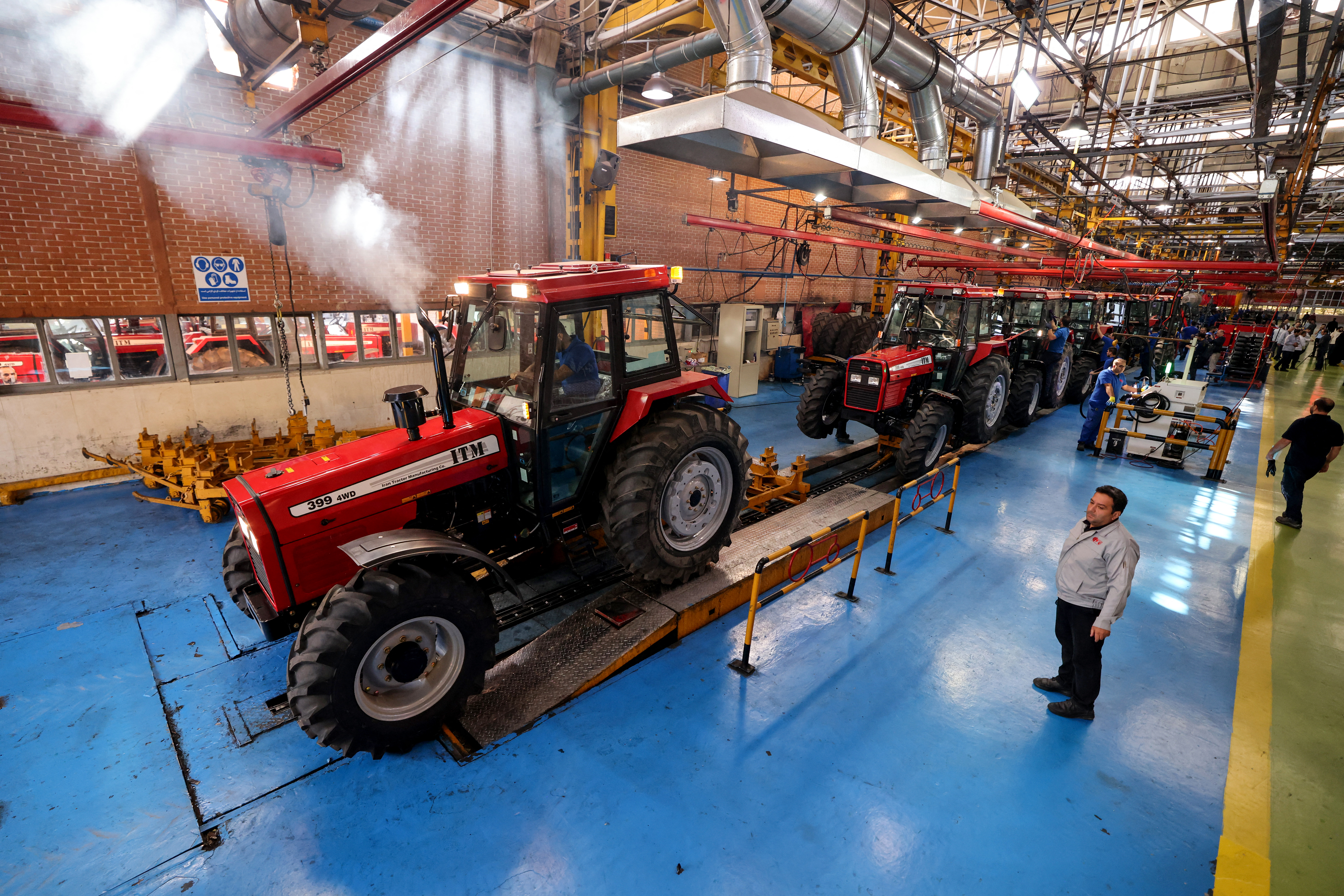 Iranian labourers work in a tractor production and assembly line at the Tabriz Tractor Factory, on September 17, 2025, in Tabriz in northwestern Iran. (Photo by ATTA KENARE / AFP)