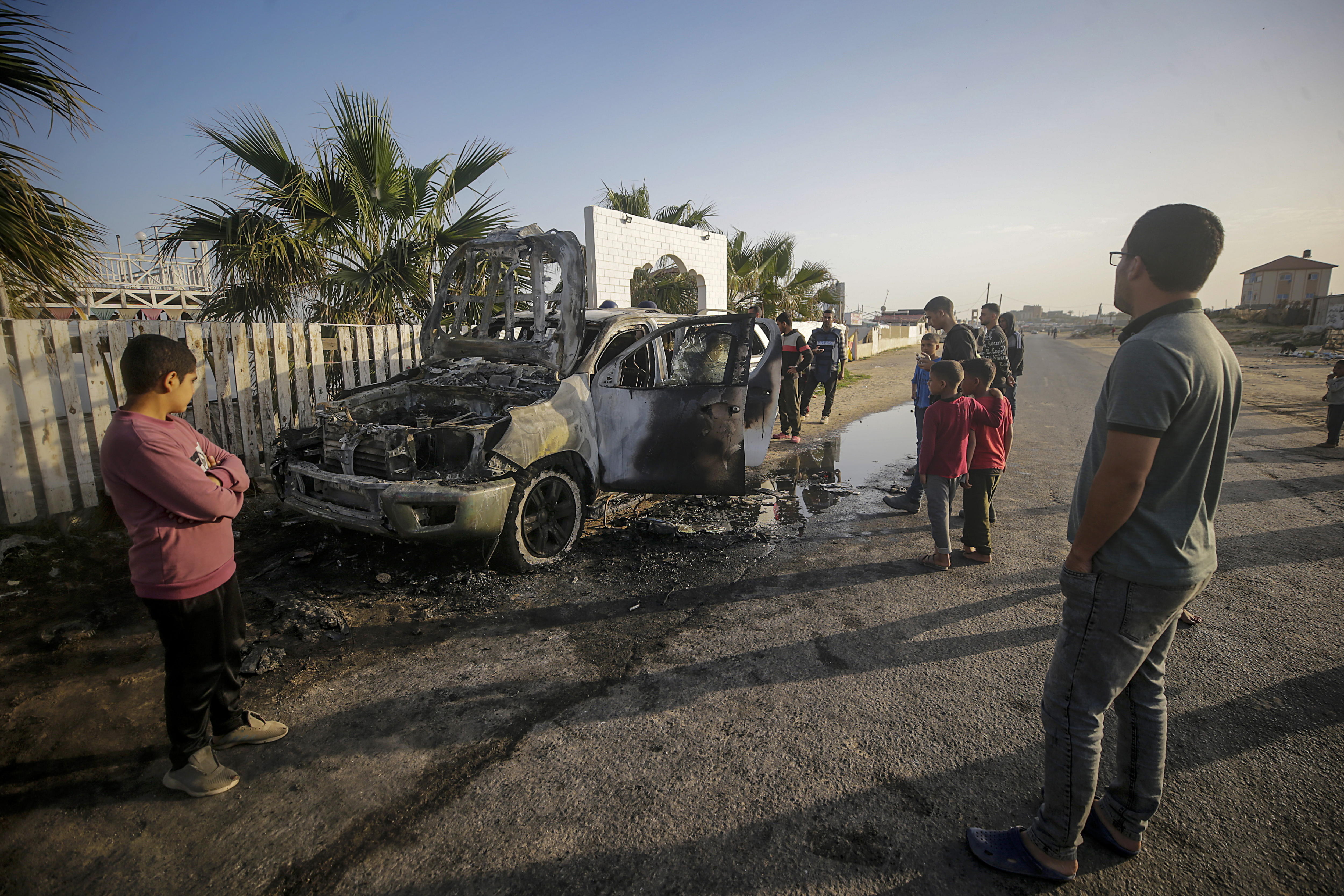Deir Al Balah (---), 02/04/2024.- People stand near a destroyed car of the NGO World Central Kitchen (WCK) along Al Rashid road, between Deir Al Balah and Khan Younis in the southern Gaza Strip, 02 April 2024. According to the Palestinian Red Crescent, at least four people from the NGO World Central Kitchen (WCK) were killed when a missile hit their convoy in Deir al Balah while they were on their way from Rafah to Gaza City to receive fresh aid delivered by the Open Arms vessel. The victims were confirmed to be a British, a Polish and an Australian citizen, while the nationality of the fourth victim was still unknown. EFE/EPA/MOHAMMED SABER