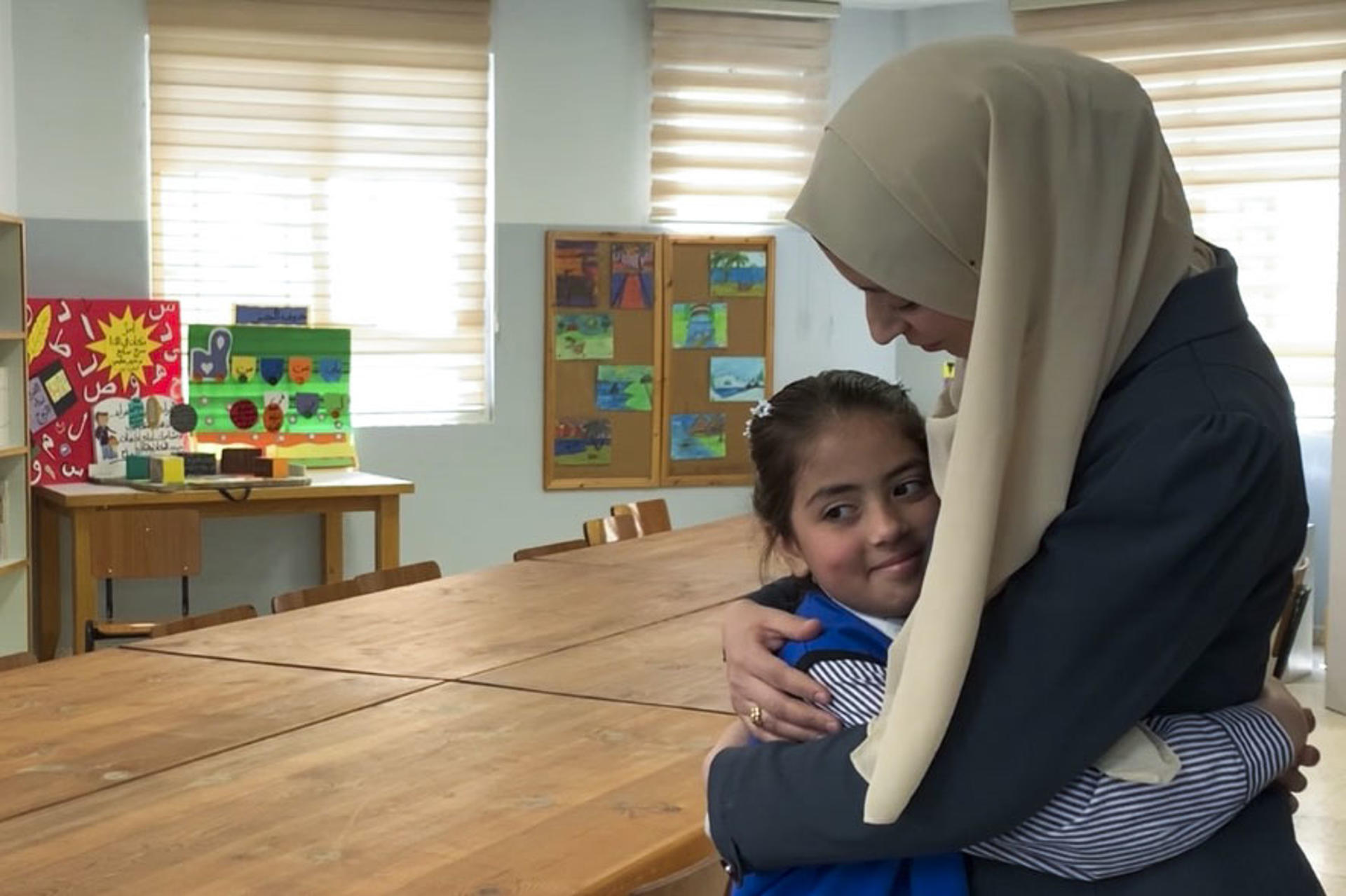 JERUSALÉN, 07/05/2025.- Anuar (d), una joven madre de 27 años, junto a su hija de 8, Tagrid, en una escuela de la UNRWA (la agencia de la ONU para los refugiados palestinos) en el campamento de Shuafat. A pocos días de que se cumpla el plazo dado por las autoridades israelíes para clausurar las escuelas de la UNRWA en Jerusalén Este, las madres del campamento de Shuafat se niegan a contemplar alternativas. "Creo que esta escuela es extraordinaria, es excepcional. Yo estudié en esta escuela y por eso traje a mi hija aquí", explica a EFE Anuar. EFE/ Jorge Dastis
