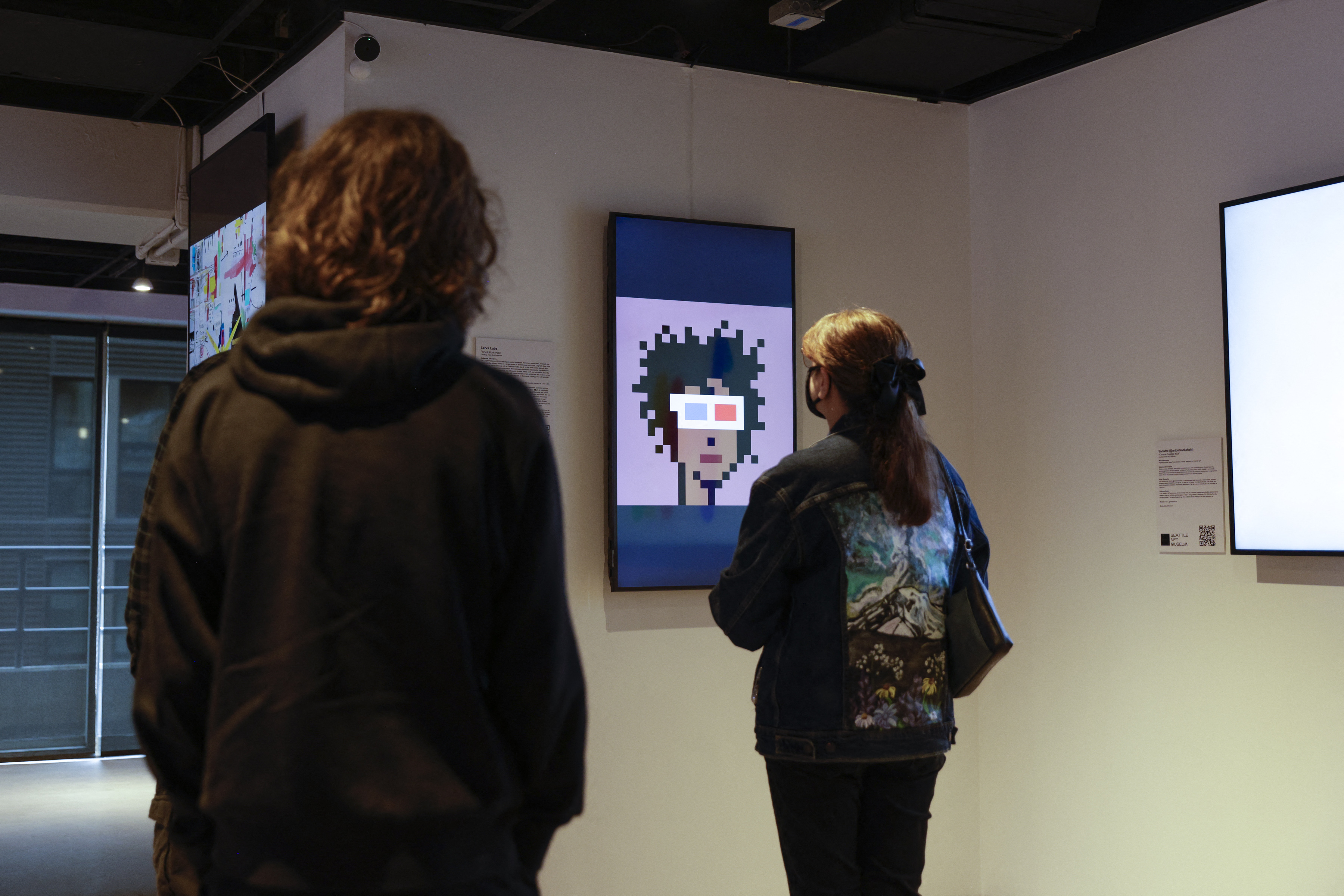 Los visitantes ven la obra de arte digital "CryptoPunk #553" de Larva Labs durante el fin de semana inaugural del Museo NFT de Seattle en Seattle, Washington, el 29 de enero de 2022.