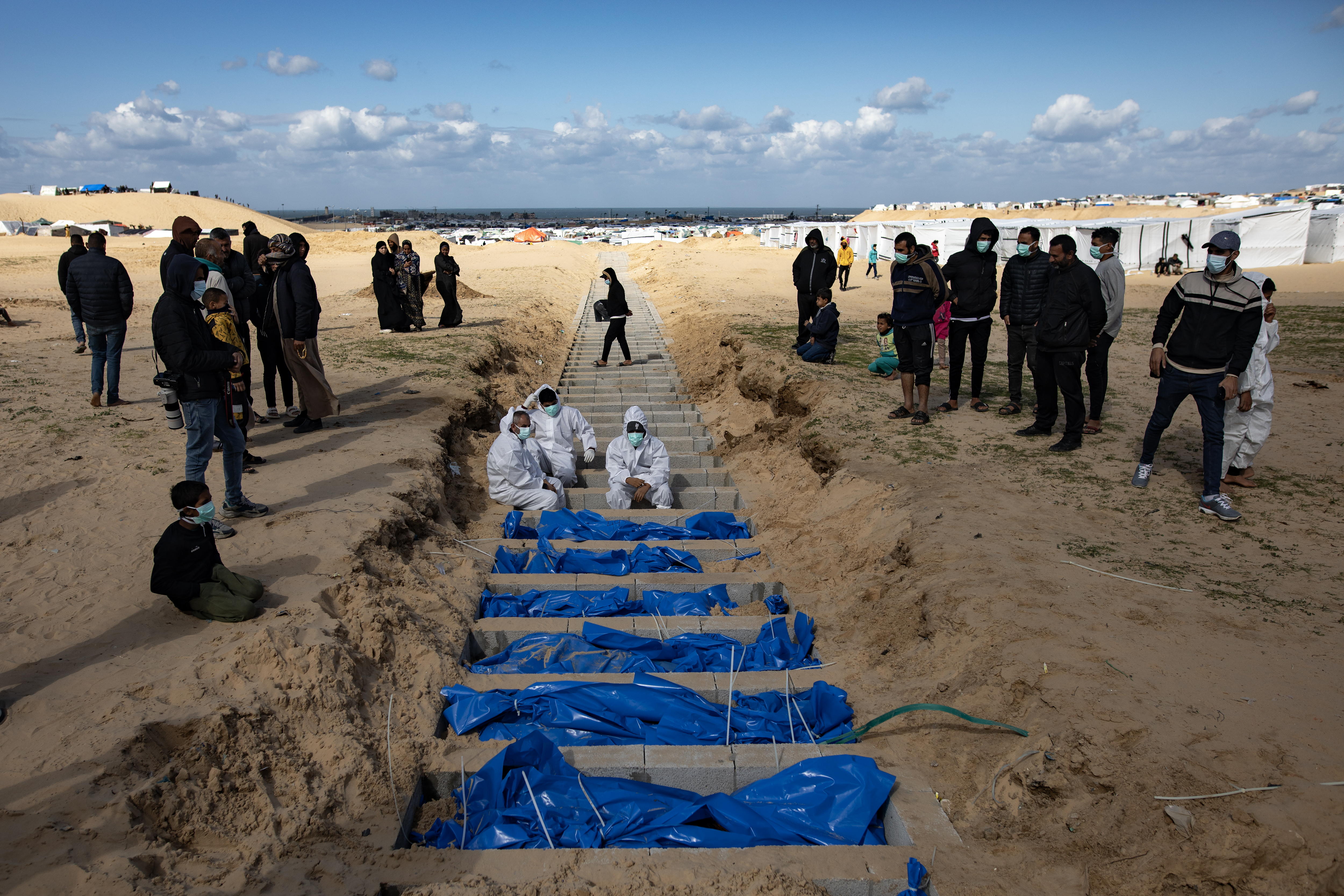 Rafah (---), 30/01/2024.- Palestinian Ministry of Health workers prepare bodies for a mass burial in the Rafah camp, south of the Gaza Strip, after receiving them from the Israeli army through the Kerem Shalom crossing, 30 January 2024. The bodies were returned after being seized by the Israeli army for identity checks. EFE/EPA/HAITHAM IMAD