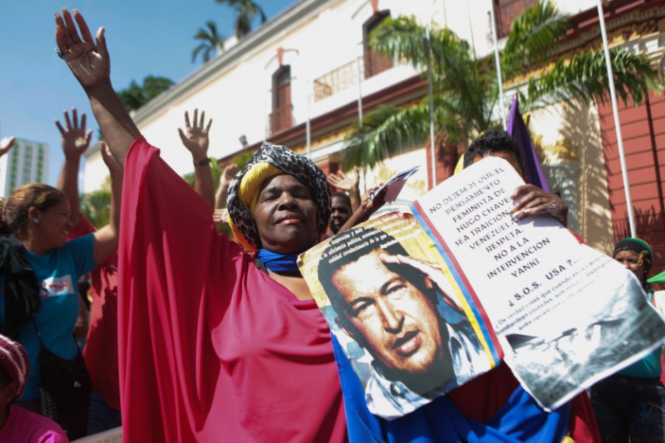 Una mujer sostiene una pancarta con la imagen del fallecido Hugo Chávez en Caracas. / EFE