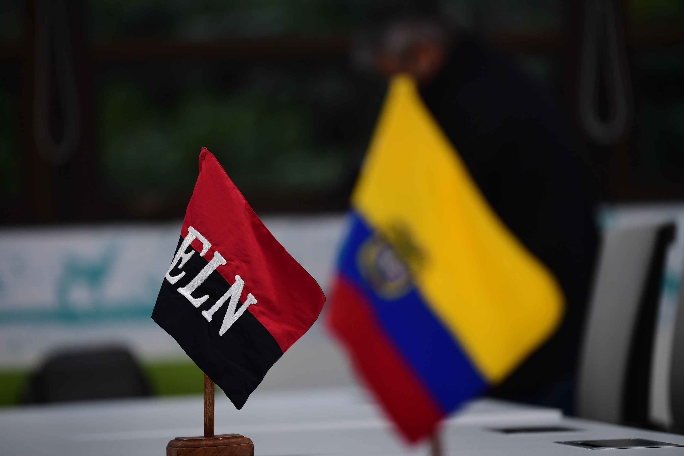 Bandera del ELN y de Colombia que se ubican frente a los negociadores de paz del ELN