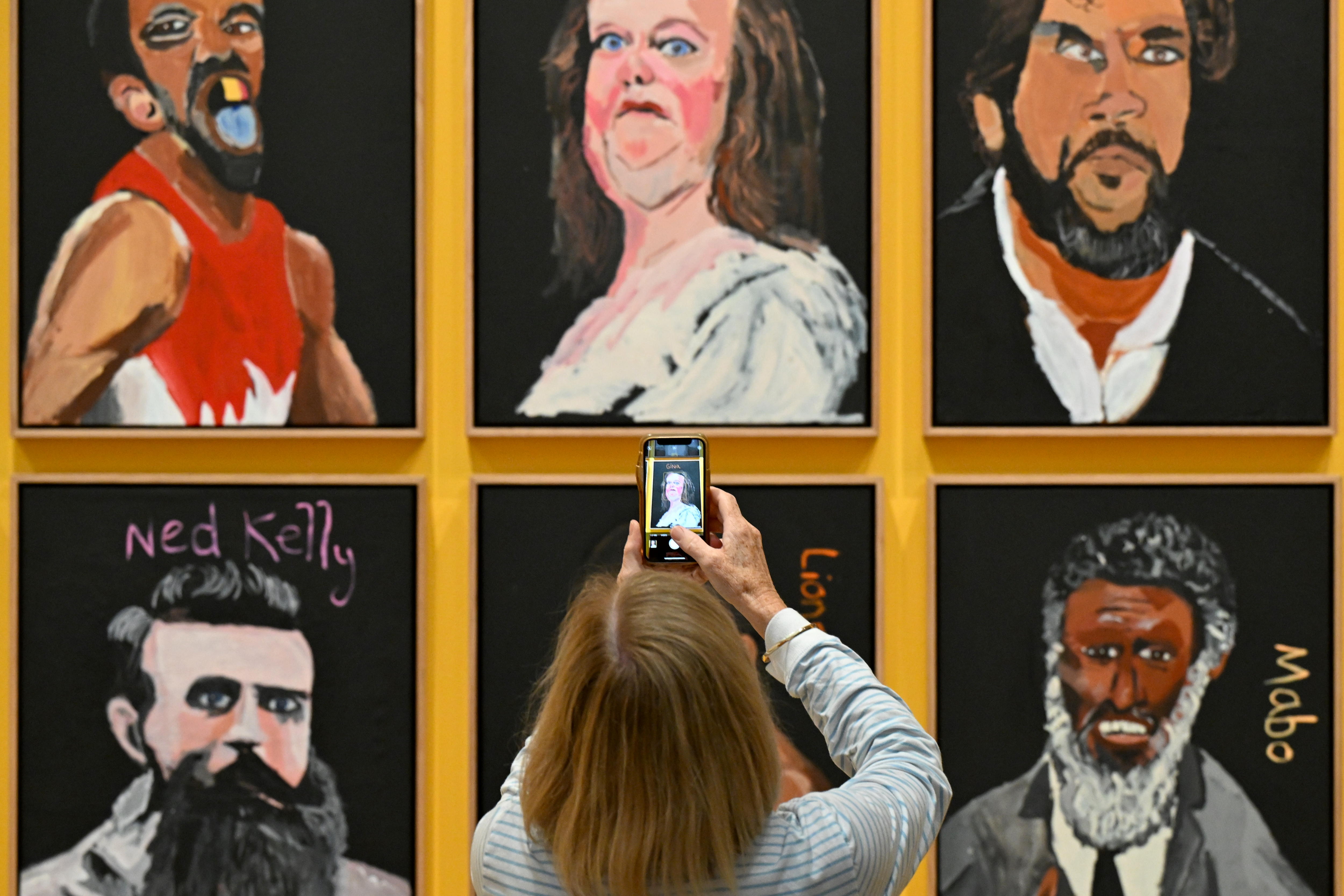 Canberra (Australia), 17/05/2024.- A visitor takes a picture of a portrait of Australian billionaire Gina Rinehart, which forms part of an artwork+titled+ëAustralia in Colour, 2021í by artist Vincent Namatjira at the National Gallery of Australia, in Canberra, Australia, 17 May 2024. EFE/EPA/LUKAS COCH AUSTRALIA AND NEW ZEALAND OUT