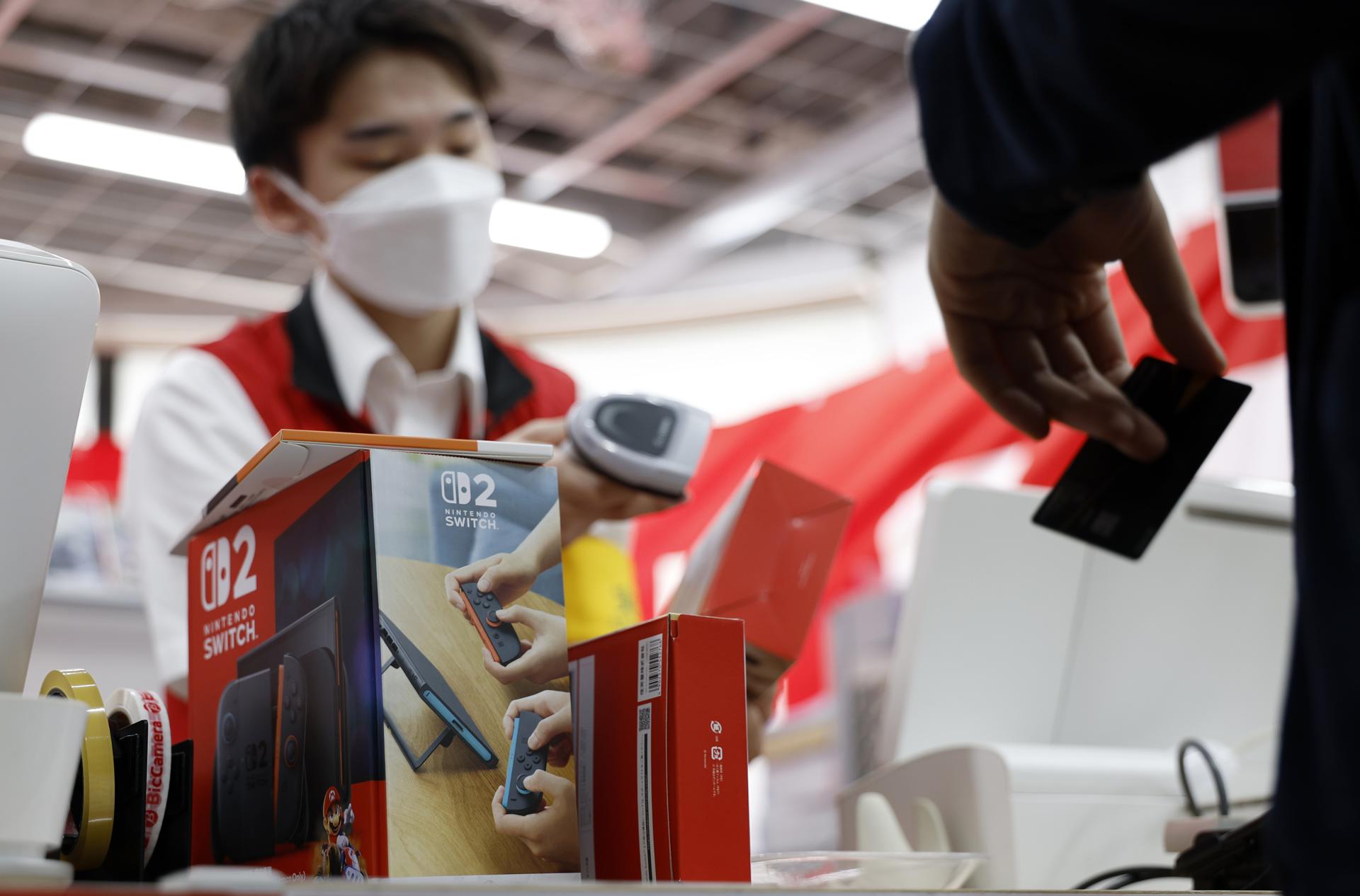 FOTODELDÍA TOKIO  (JAPÓN), 05/06/2025.- Un empleado de una tienda de electrónica de consumo prepara la nueva consola Nintendo Switch 2 para un cliente en Tokio, Japón, este jueves, día en el que Nintendo ha lanzado su nueva consola, la Nintendo Switch 2. EFE/ Franck Robichon
