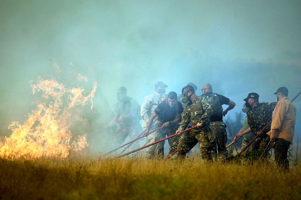 Soldados y campesinos tratan de apagar el fuego en una villa en Macedonia del Norte, donde se declaró el estado de emergencia por los incendios.