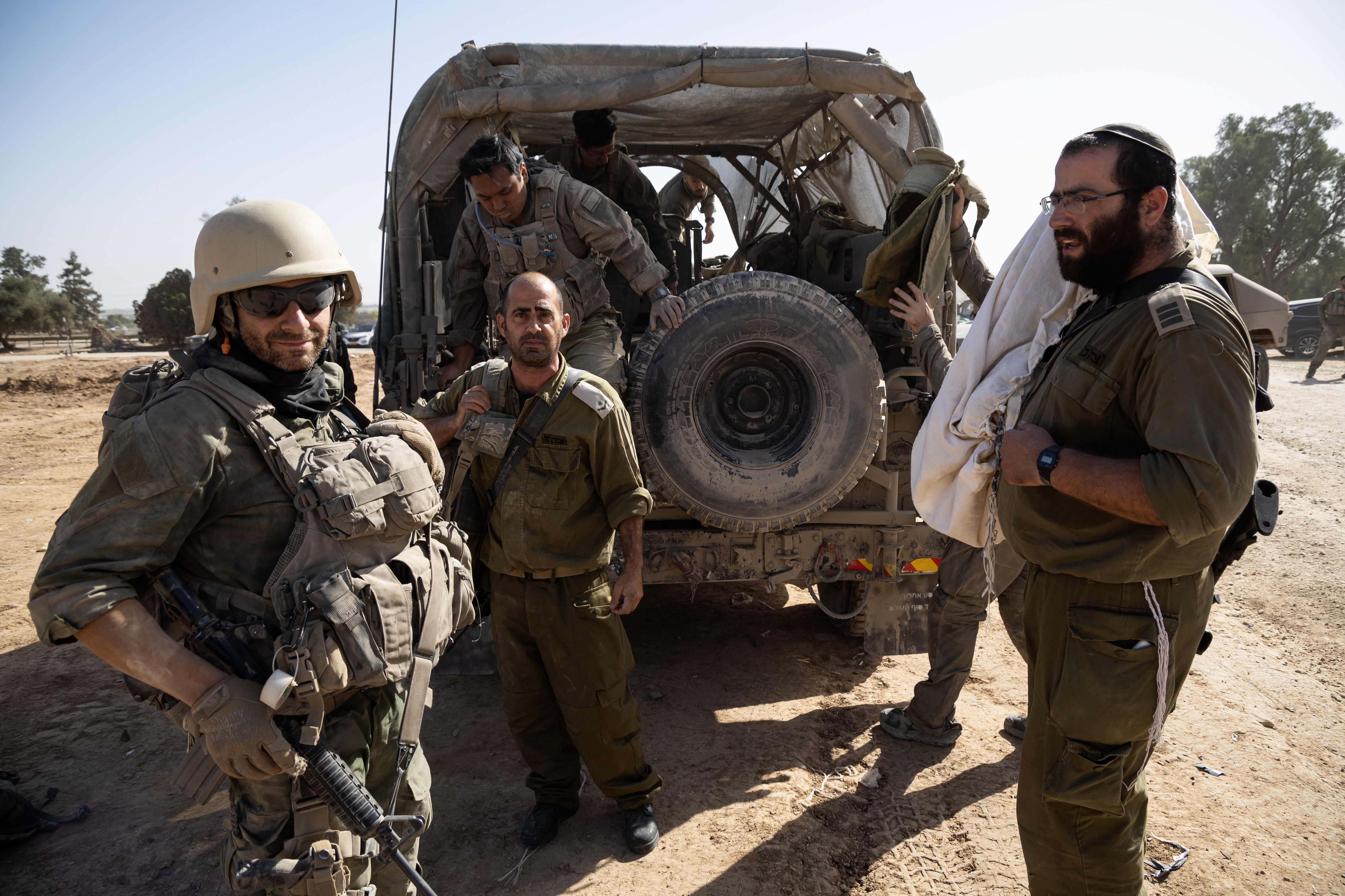 Undisclosed (Israel), 23/11/2023.- Israeli army soldiers, on of them carrying a Torah scroll (R), as their unit returns from Gaza, at the border with the Gaza Strip, southern Israel, 23 November 2023. More than 12,700 Palestinians and at least 1,200 Israelis have been killed, according to the Israel Defense Forces (IDF) and the Palestinian health authority, since Hamas militants launched an attack against Israel from the Gaza Strip on 07 October, and the Israeli operations in Gaza and the West Bank which followed it. As part of Israel's 'ground operation' in the Gaza Strip, aerial strikes were carried out on over 300 Hamas targets over the last day, the IDF announced on 23 November. EFE/EPA/CHRISTOPHE PETIT TESSON