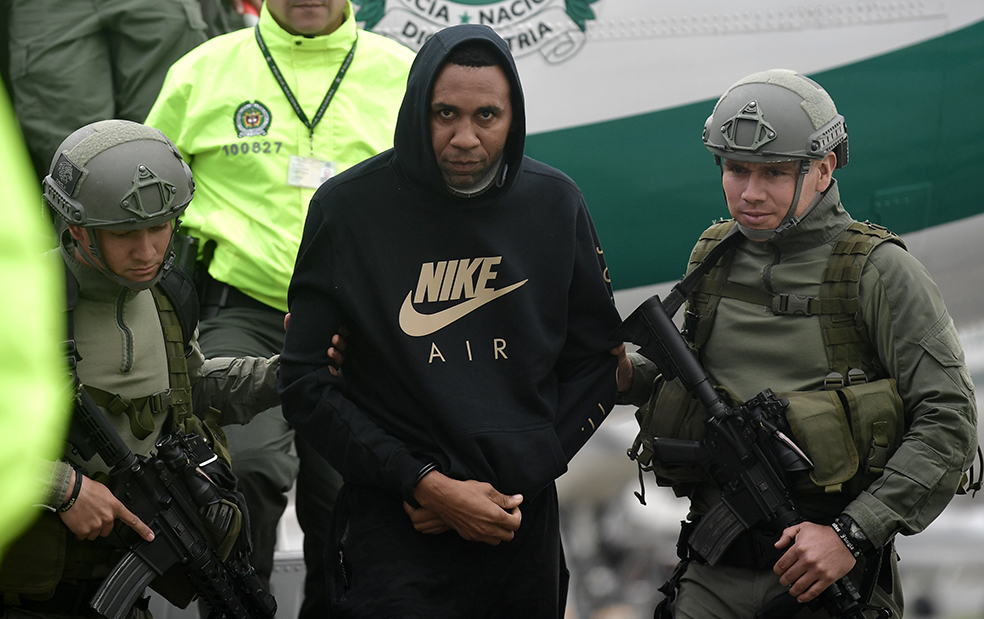 El exfutbolista colombiano Jhon Viáfara  camina escoltado por integrantes de la Policía a su llegada a la Dirección de Antinarcóticos en el Aeropuerto Militar de Catam en Bogotá. Viáfara, detenido el martes y pedido en extradición por EE.UU. por narcotráfico, era el encargado de pagar a quienes transportaban cocaína en lanchas y avionetas hacia centro y Norteamérica, informó la Policía Nacional . / Óscar Pérez