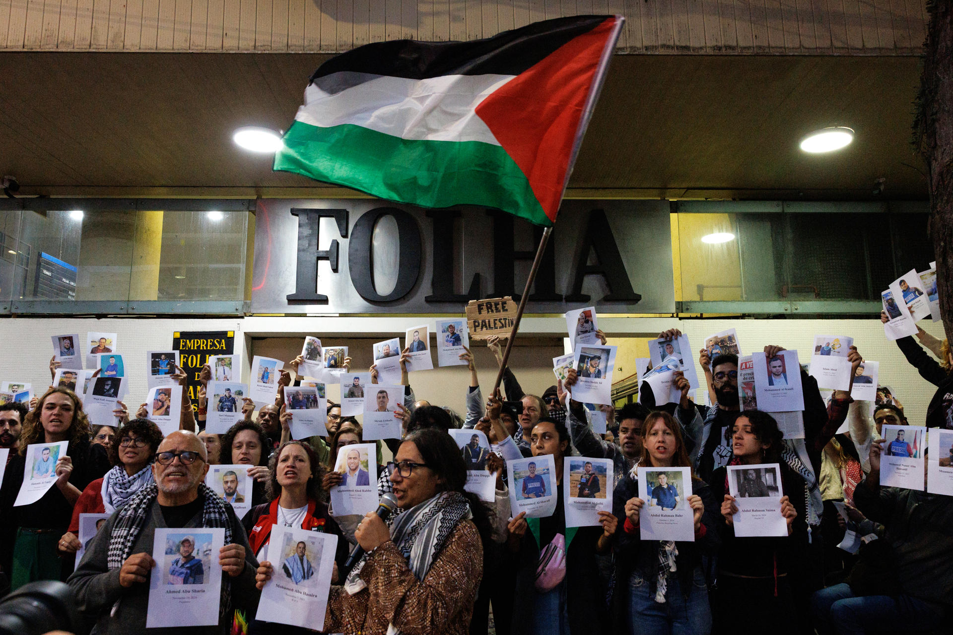 AME5846. SAO PAULO (BRASIL), 07/10/2025.- Personas sostienen carteles con la imágen de periodistas muertos en Gaza, frente a la sede del diario Folha este martes, en Sao Paulo (Brasil). Manifestantes en apoyo a la flotilla de activistas que partió a la Franja de Gaza se reunieron en una protesta por la forma en que la prensa brasileña ha abordado el conflicto entre Israel y Palestina. EFE/ Isaac Fontana
