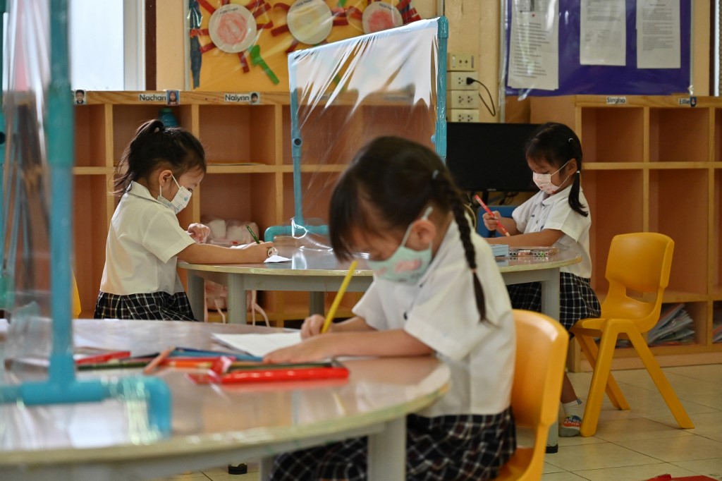 Los estudiantes en Tailandia asisten a clases equipadas con mesas divididas por plásticos para evitar la propagación del nuevo coronavirus COVID-19