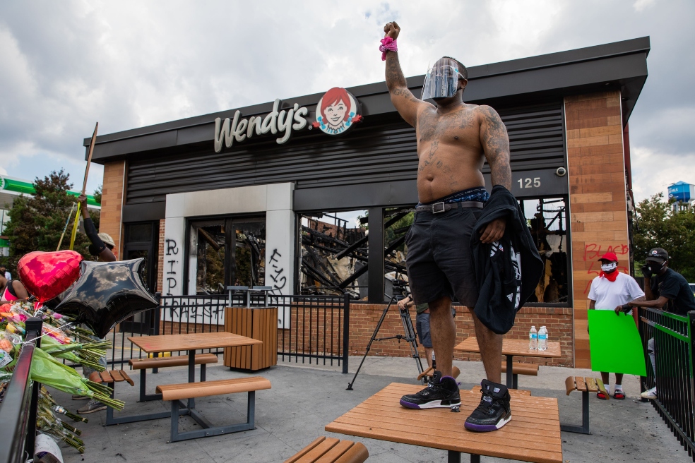 Un hombre protesta en el restaurante donde Rayshard Brooks, afroamericano, murió por un disparo de un policía.