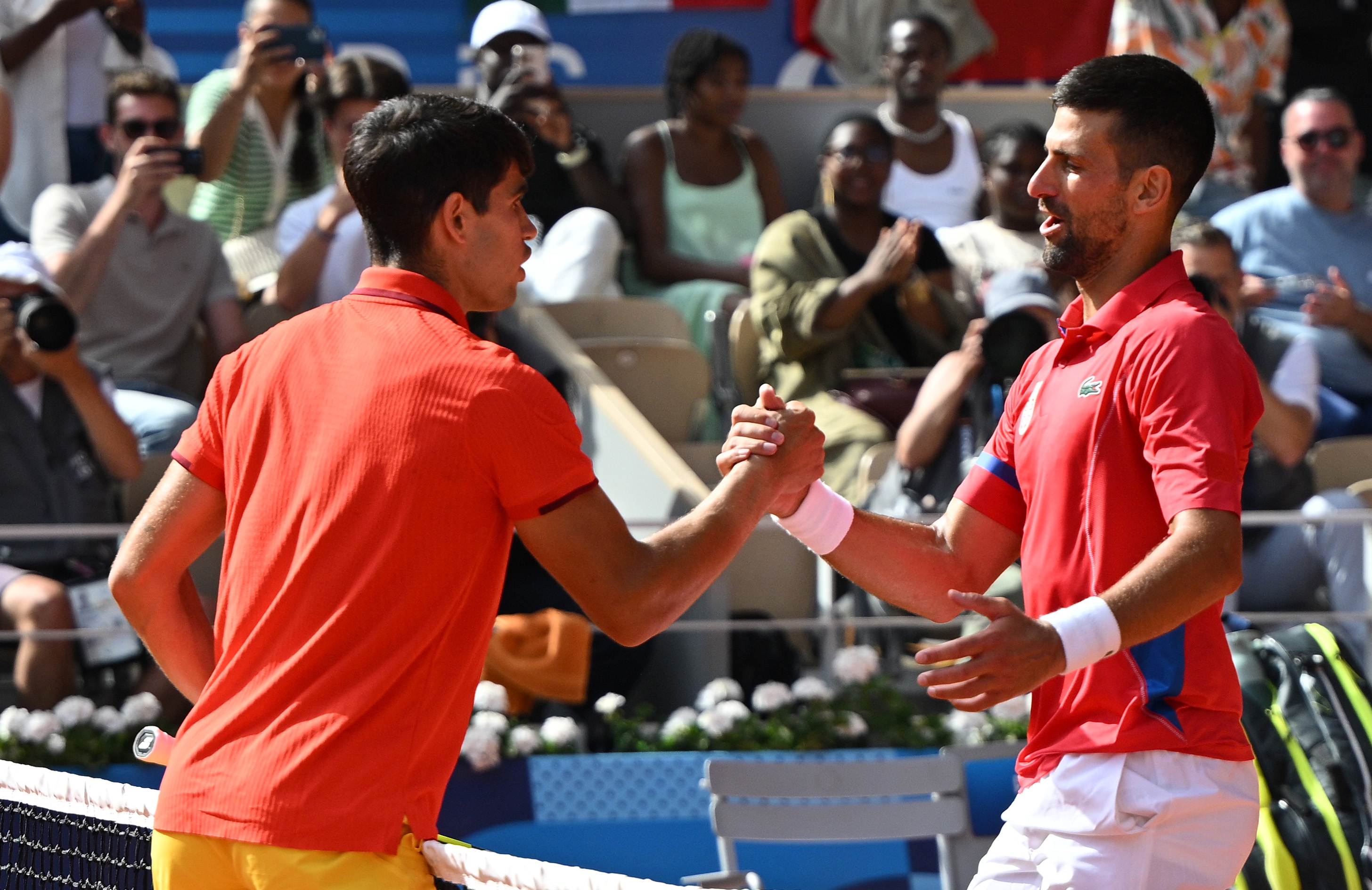 Paris (France), 04/08/2024.- Novak Djokovic of Serbia (R) shakes hands with Carlos Alcaraz of Spain (L) after the Men Singles gold medal match of the Tennis competitions in the Paris 2024 Olympic Games, at the Roland Garros in Paris, France, 04 August 2024. (Tenis, Francia, España) EFE/EPA/CAROLINE BLUMBERG
