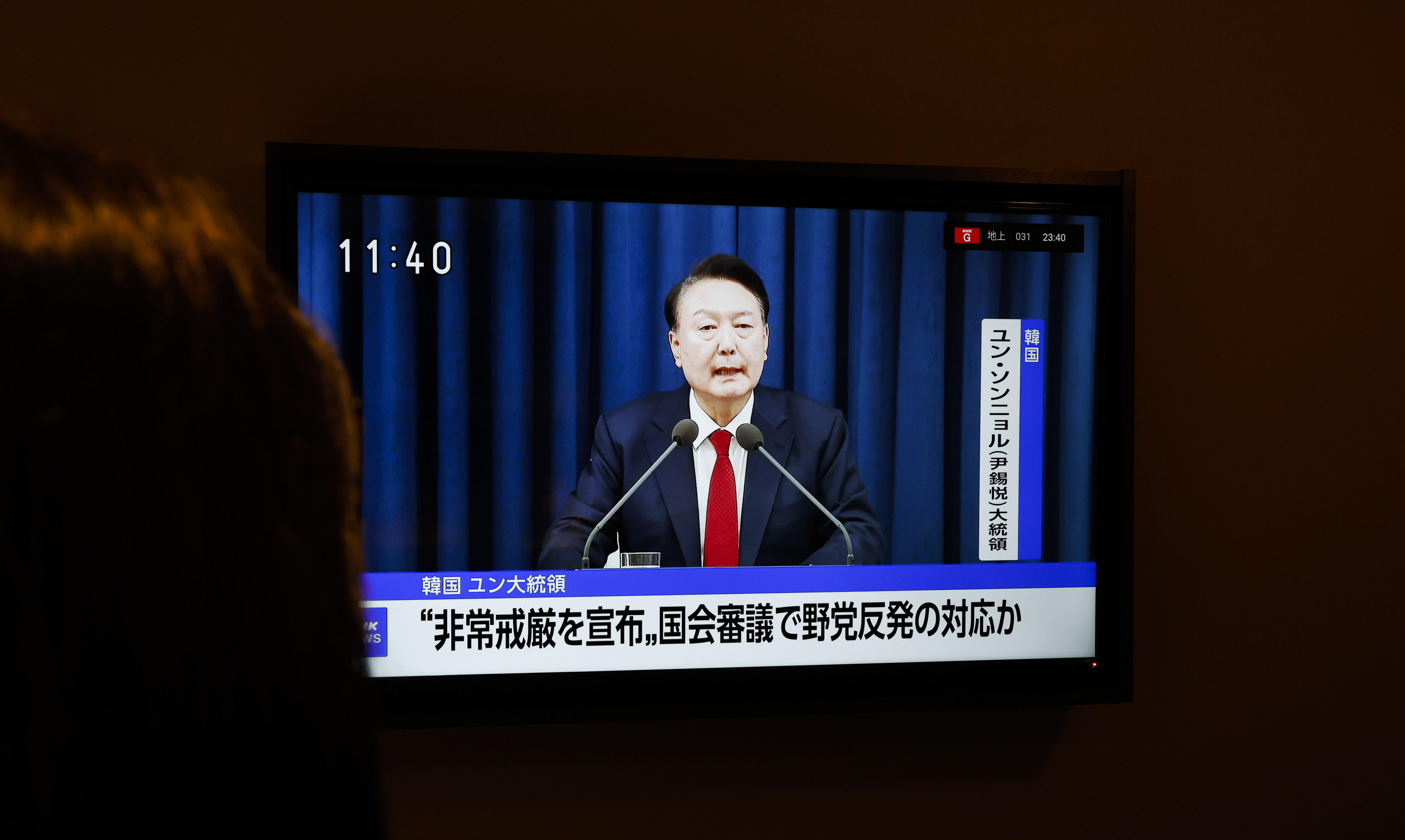 Sapporo (Japan), 03/12/2024.- A South Korean tourist watches a Japanese TV broadcast showing South Korean President Yoon Suk Yeol declaring martial law in a televised emergency address delivered from the presidential office in Seoul, in Sapporo, Japan, 03 December 2024. The South Korean President addressed the nation citing the need to root out pro-North Korean forces and uphold the constitutional order. (Japón, Corea del Sur, Seúl) EFE/EPA/JEON HEON-KYUN