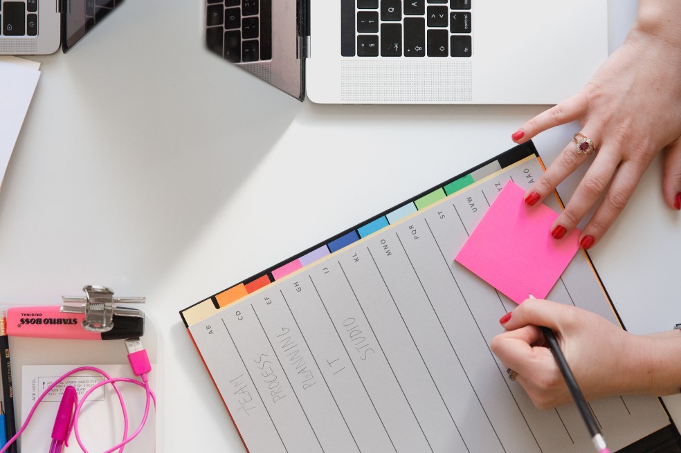 Una mujer en un computador y una agenda.