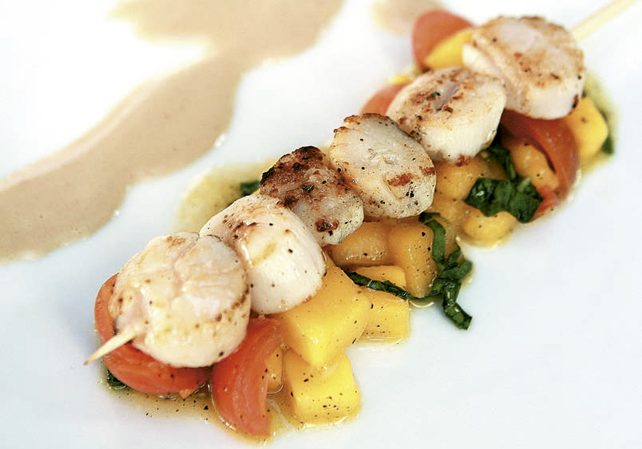 Pincho de vieiras sobre mango con salsa de maní y coco
