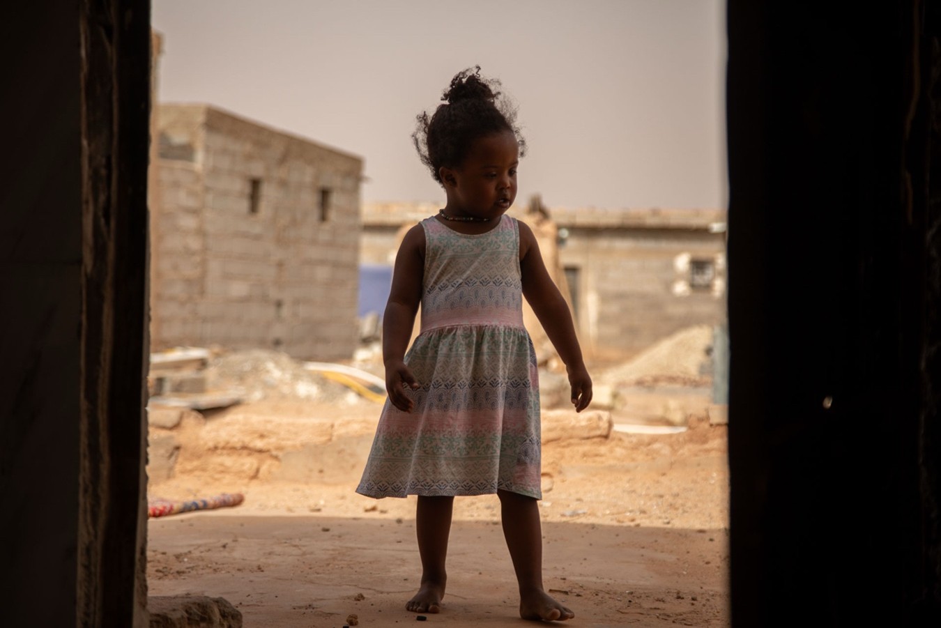 Fatma en la entrada de la casa familiar. Más del 40 % de la población en los campamentos es menor de edad. Campamentos de refugiados saharauis, Tinduf, Argelia.
