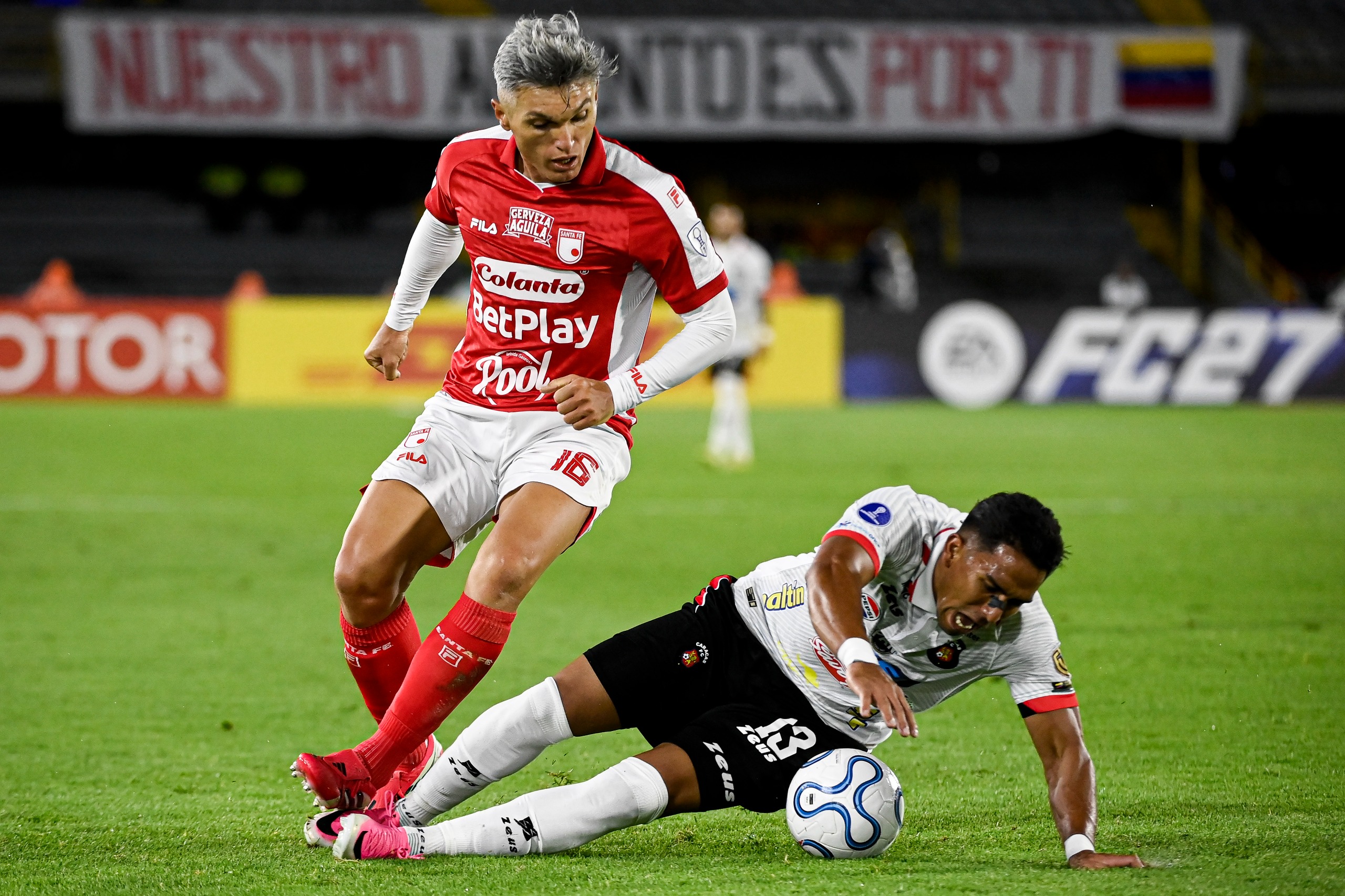 Daniel Torres elude a un rival durante el partido entre Santa Fe y Caracas en el estadio El Campín de Bogotá por los playoffs de la Copa Sudamericana 2026.