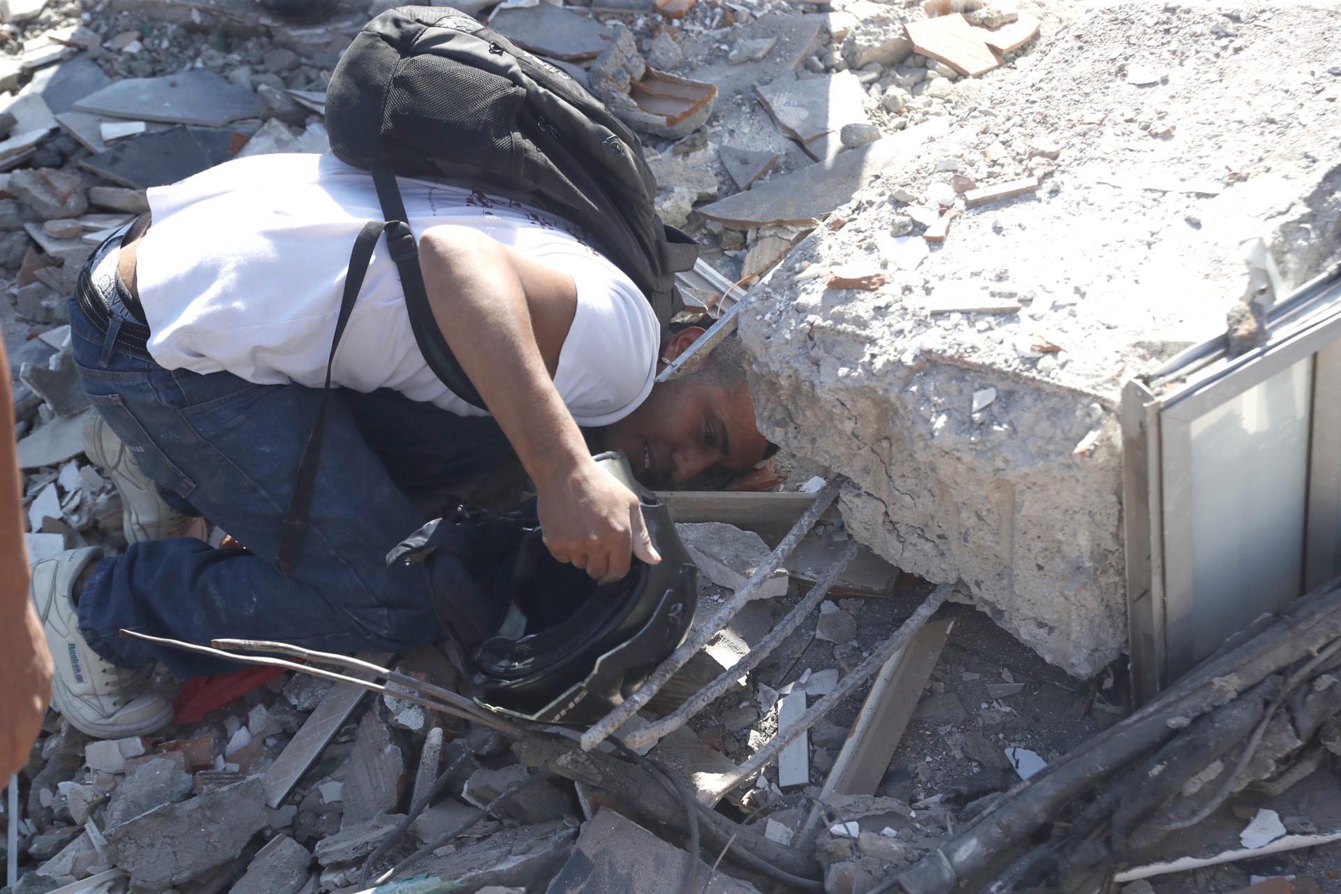 AME7645. CALI (COLOMBIA), 10/08/2026.- Una persona busca en los escombros de un edificio colapsado este lunes, en Cali (Colombia). Al menos 20 edificios sufrieron graves daños por consecuencia del terremoto de magnitud 7,4 que sacudió la mayor parte del país, con epicentro en la zona del Pacífico. EFE/ Ernesto Guzmán
