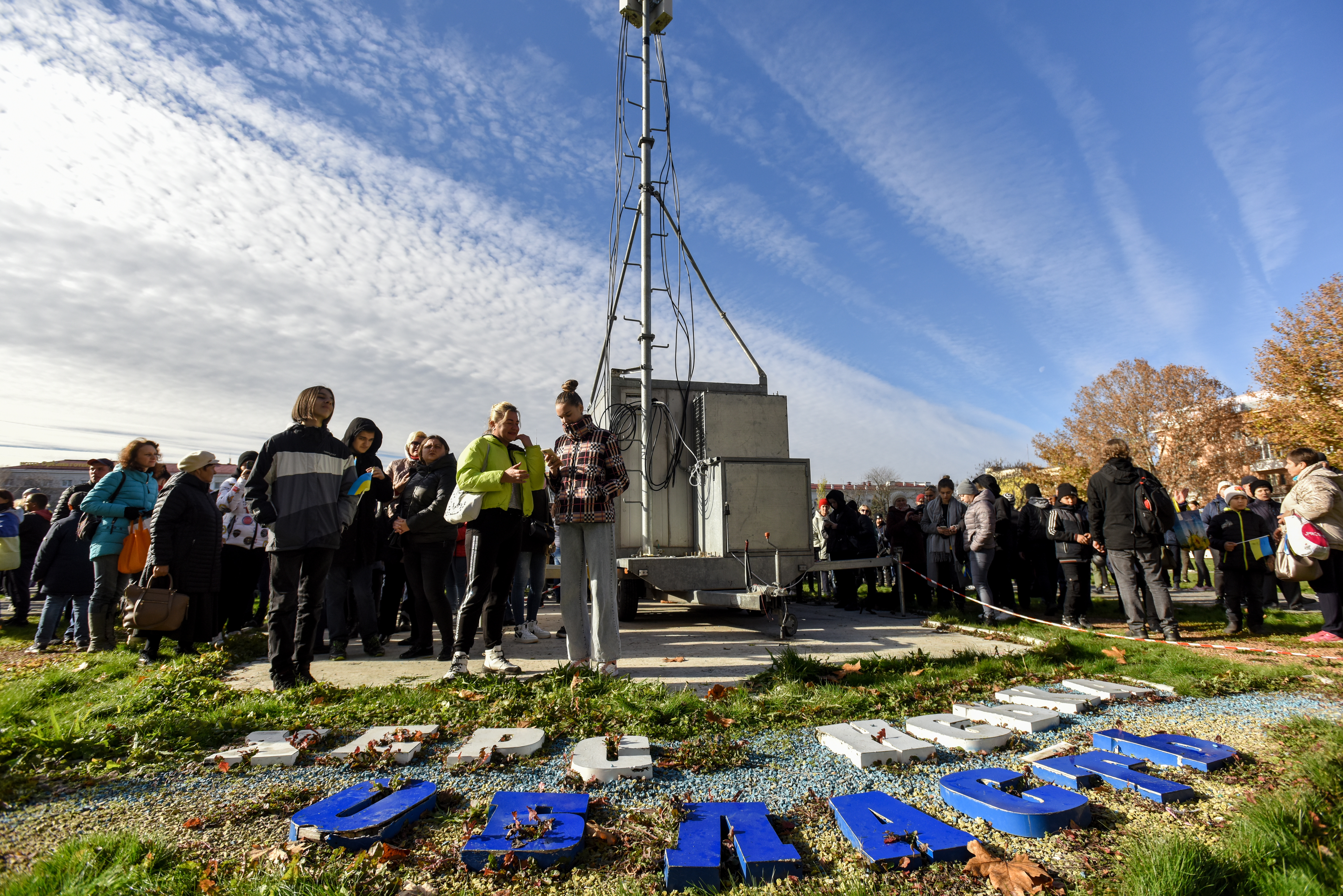 Kherson (Ukraine), 14/11/2022.- People use their mobile phones near the mobile antenna in the recaptured city of Kherson, Ukraine, 14 November 2022. Ukrainian troops entered Kherson on 11 November after Russian troops had withdrawn from the city. Kherson was captured in the early stage of the conflict, shortly after Russian troops had entered Ukraine in February 2022. (Rusia, Ucrania) EFE/EPA/OLEG PETRASYUK