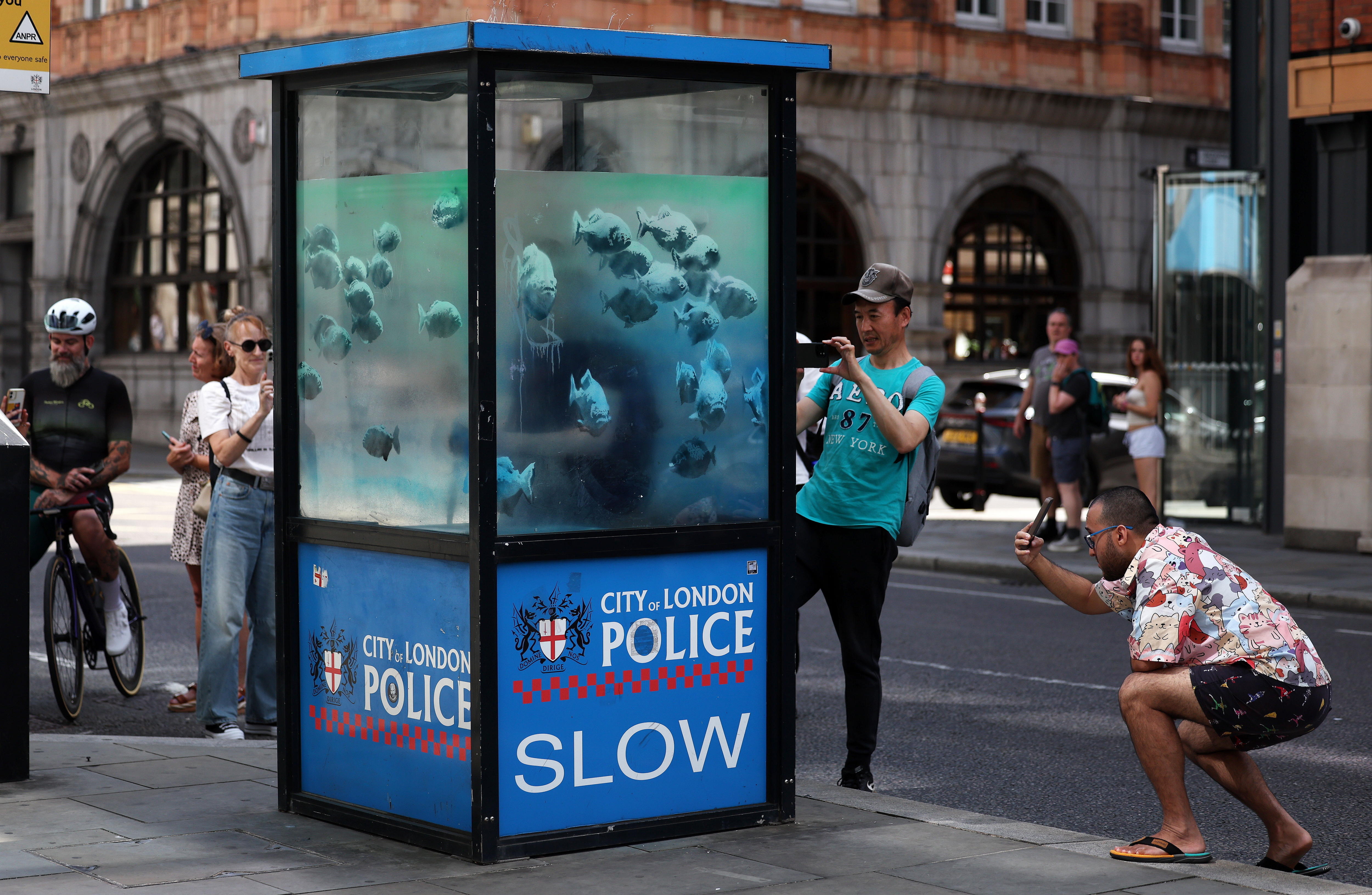 London (United Kingdom), 11/08/2024.- People gather to look at an artwork by Britain-based street artist Banksy on an old police sentry box in the City of London in London, Britain, 11 August 2024. It is the seventh animal artwork claimed by the artist in the past week. Banksy has claimed one art piece a day for seven days, posting a photo at 1pm local time on social media every day. (Reino Unido, Londres) EFE/EPA/ANDY RAIN